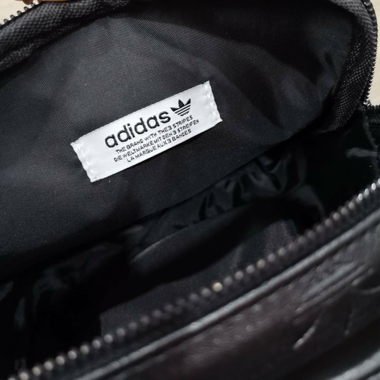 ADIDAS 2WAYS TOP HANDLE BAG กระเป๋าถือเเละสะพายเป้แบบ 2Ways ดีไซน์ทรงเหลี่ยมขนาดกำลังดีิ น้ำหนักเบา วัสดุหนังเรียบสวยสีดำปั้มโลโก้แบรนด์รอบใบ หูจับถนัดมือ มีช่องหลัก2ช่องแยกเป็นสัดส่วน เปิดปิดด้วยซิปสะดวกใช้ หัวซิปแบรนด์ ภายในมีโลโก้ มีสายสะพาย2เส้น สายถอ