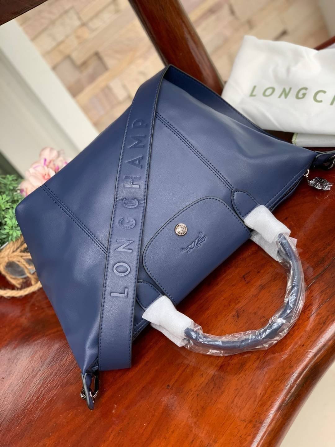 Longchamp LE PLIAGE CUIR TOP HANDLE BAG S เรียกว่าเป็นกระเป๋าอีกหนึ่งรุ่นที่ไม่ว่ายังไงก็ฮอตฮิตและติดเทรนด์ตลอดไม่เคยเปลี่ยนกับ ทรง Le Pliage Cuir หนึ่งในตระกูลกระเป๋าสุดไอคอนิกจากแบรนด์ เมื่อรุ่น Le Pliage Cuir ในรูปแบบของหนังแกะ Metis ได้ถือกำเนิดขึ้นใน