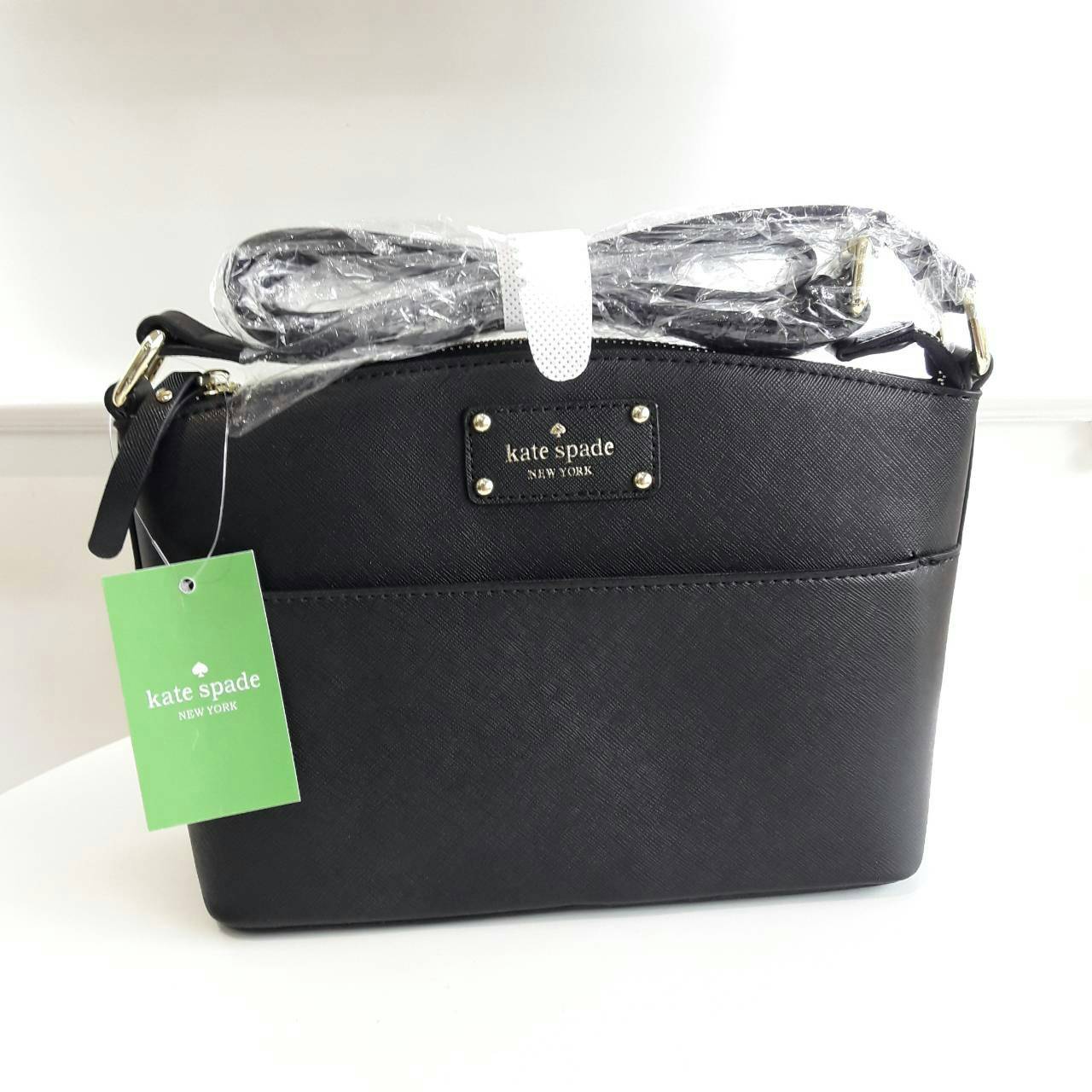 Kate Spade New York Mini Cross Body Bag กระเป๋าถือหรือสะพายหนัง Saffiano สวยหรูอยู่ทรงสไตล์ PRADA ด้านหน้าประดับโลโก้สีทองสวยไฮโซ มาพร้อมสายสะพายยาวปรับได้ ภายในมีช่องซิปและช่องเล็ก ซับในอย่างดีสกรีนลายตามแบบฉบับของแบรนด์ภายในกว้างจุใส่กระเป๋าสตางค์ใบยาวข