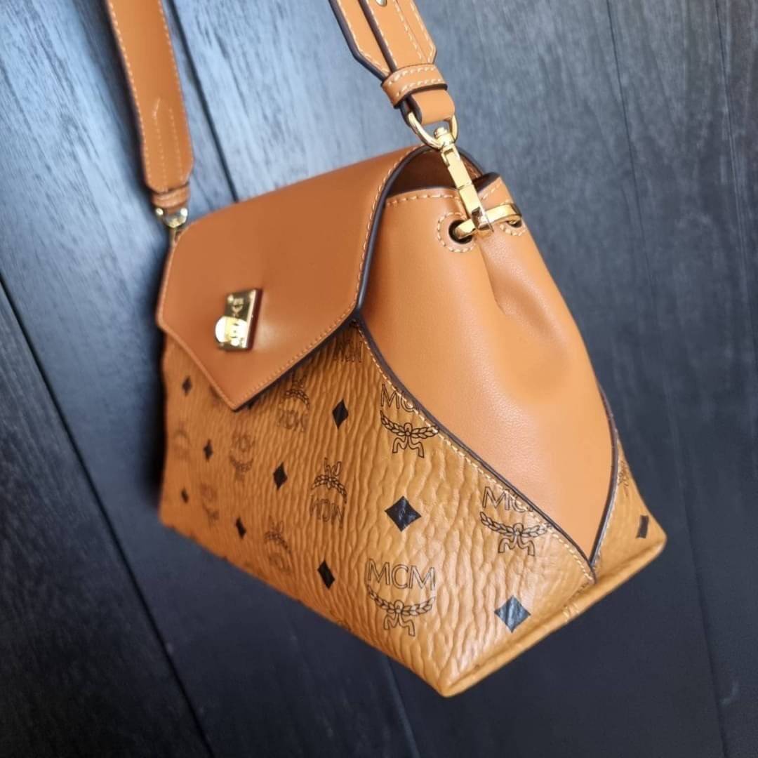 M.C.M ESSENTIAL CROSSBODY IN VISETOS กระเป๋าสะพายข้าง สวยอยู่ทรง ดีไซน์ไม่ซ้ำใคร มาพร้อมสายสะพายถึง 2 แบบ ปรับเปลี่ยนใช้ได้ไม่มีเบื่อ วัสดุหนังแคนวาสสลับหนังแท้ เปิด-ปิดกระเป๋าด้วยตัวบิดล็อคแน่นหนา ด้านหลังมีช่องเก็บบัตรได้ ภายในโล่งกว้าง แบ่งสัดส่วน เป็น