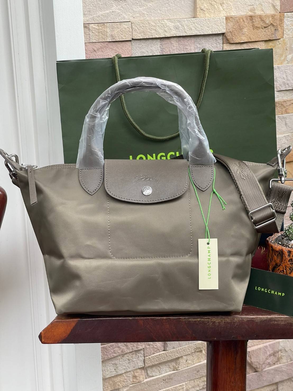 Longchamp LE PLIAGE NÉO TOP HANDLE BAG อีกหนึ่งรุ่นยอดนิยม ที่สาวๆ ต้องมีไว้เก็บไว้สักใบ กระเป๋าโท้ทใบนี้ มาพร้อมกับสีที่มีสไตล์เรียบง่าย มีสายสะพายยาวปรับสั้นยาวได้ช่วยให้คุณสามารถสะพายไหล่ได้อย่างสบาย ในตัวสายปักโลโก้อันเป็นสัญลักษณ์ ในขณะที่ที่ปิดแบบซิ