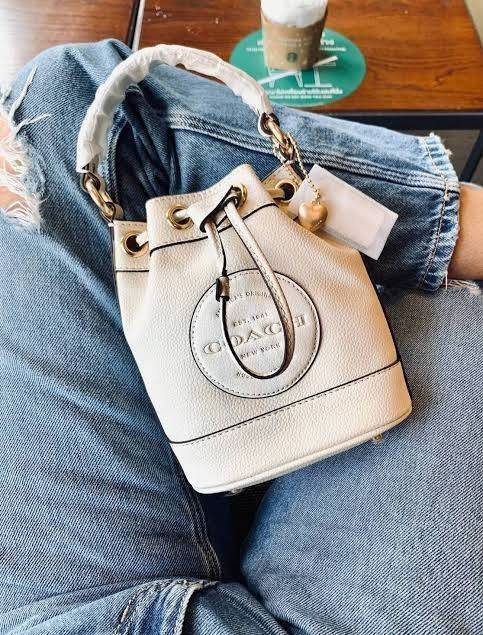 COACH DEMPSEY BUCKET BAG 15 WITH COACH PATCH AND HEART CHARM สวยงามด้วยดีไซน์ทรงตะกร้าแบบมินิมอลแสนน่ารัก ดีเทลสะดุดตา รูปทรงจดจำง่าย ถือแบบชิคๆ หรือยิ่งไปกว่านั้น สายสะพายของกระเป๋าก็สามารถถอดออกเพื่อเปลี่ยนรูปแบบการสะพายได้ทั้งแบบสะพายไหล่และสะพายคาดลำต