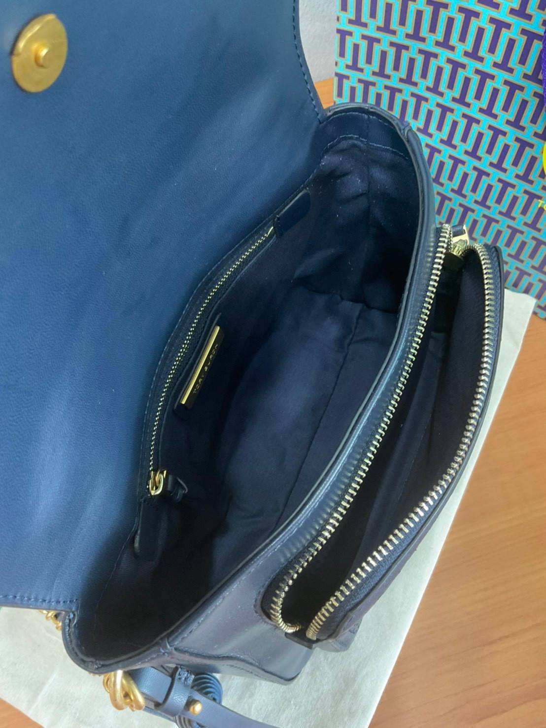 Tory Burch Fleming Satchel Bag รุ่น 45147 สี Royal Navy กระเป๋าสะพาย Crossbody ทรงสวย ดีไซน์เก๋ สุดคลาสสิค เพิ่มดีเทลโลโก้แบรนด์บนฝากระเป๋าอัพลุคให้ดูเท่ห์ และ พู่หนังถอดได้ วัสดุหนังแท้ สัมผัสนุ่มมือ หนังสวย น้ำหนักเบา ตั้งอยู่ทรง เปิดปิดด้วยกระดุมแม่เหล