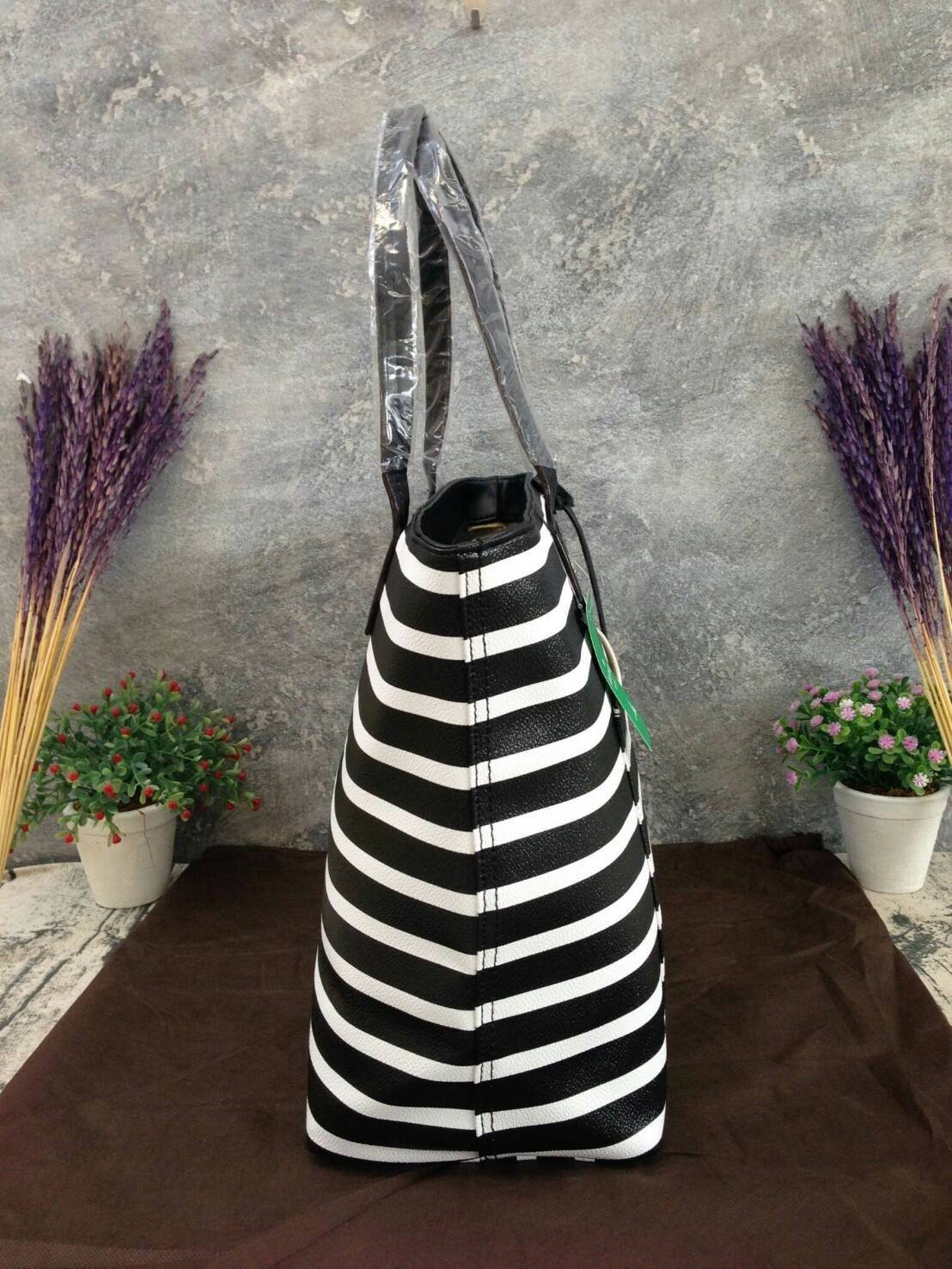 KATE SPADE HYDE LANE STRIPED RILEY LEATHER TOTE BAG กระเป๋าสะพายทรง Tote Bag หนังสวยอยู่ทรง โดดเด่นที่สีทูโทนลายทางห้อยโลโก้ TAGcที่หูกระเป๋า ด้านหน้าประดับโลโก้ มี1ช่องใส่ของ ภายในมีช่องซิป และช่องใส่มือถือ กว้างและจุ ใส่ ipad notebook เอกสาร A4 กระเป๋าส