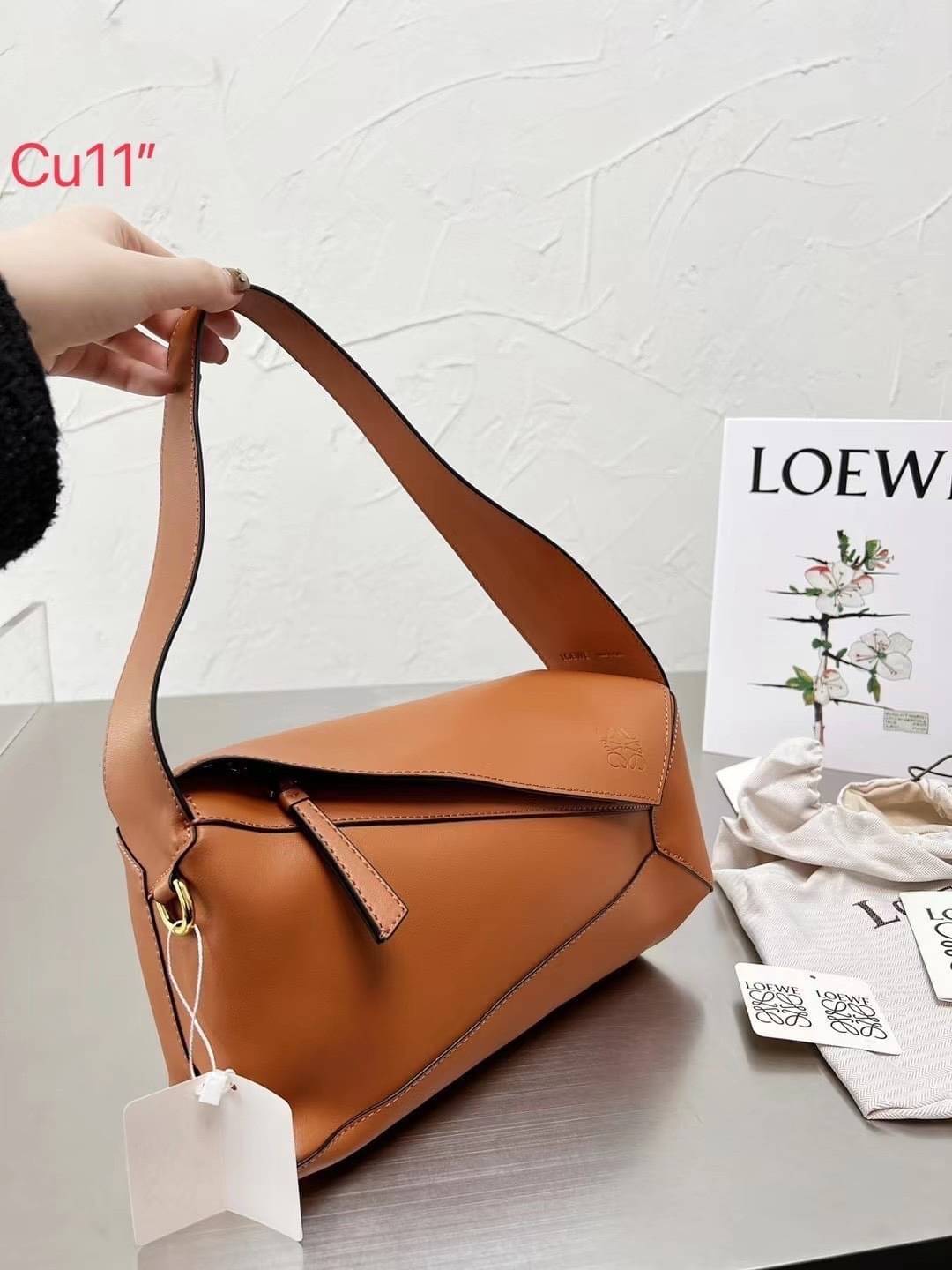 LOEWE Puzzle Hobo bag in nappa calfskin กระเป๋าสะพายไหล่มีความพิเศษในหลายด้าน ไม่ว่าจะเป็นรูปทรงที่แปลกใหม่ มินิมอลด้วยโลโก้อนาแกรมแบบประทับ ดูหรู เป็นกระเป๋า Unisex ที่ไม่ว่าคุณจะเป็นผู้หญิงหรือผู้ชายก็ใช้งานได้