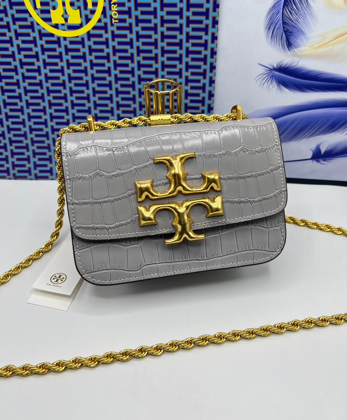 6 สี Tory Burch Croc Eleanor Small Bag / TORY BURCH ELEANOR CROC EMBOSSED LEATHER กระเป๋าสะพายหนังพิมพ์ลายจระเข้ ดีไซน์หรูหรา โด่นเด่นด้วยโลโก้แบรนด์อะไหล่ด้านหน้า และสายสะพายโลหะสีทอง