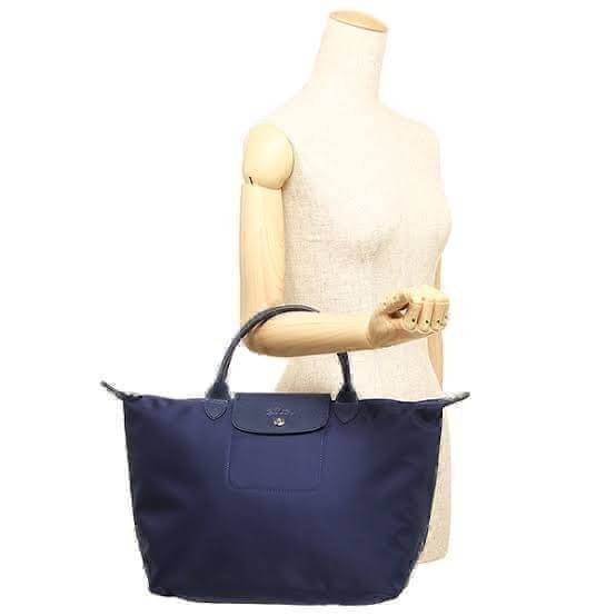 Longchamp Le Pliage Neo Size M มาพบกับกระเป๋ารุ่นยอดนิยม ที่สาวๆ ต้องมีไว้เก็บไว้สักใบ กระเป๋าโท้ทใบนี้ มาพร้อมกับสีที่มีสไตล์เรียบง่าย มีสายสะพายยาวช่วยให้คุณสามารถสะพายไหล่ได้อย่างสบาย ในขณะที่ที่ปิดแบบซิปช่วยให้คุณมั่นใจได้ว่าของด้านในมีความปลอดภัย Le 