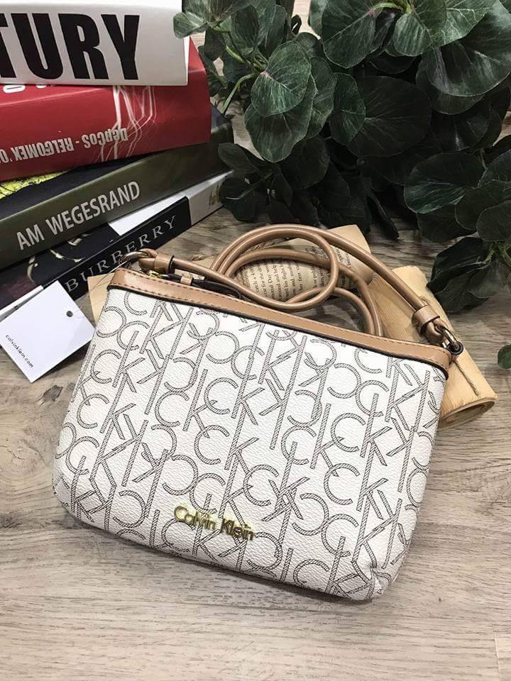 Calvin Klein Cross Body Bag กระเป๋าสะพายรุ่นใหม่ล่าสุดหนังสวย สกรีนลาย Signature แบรนด์รอบใบ ประดับโลโก้แบรนด์ สีทองด้านหน้า เปิดปิดด้วยซิป น้ำหนักเบา ภายใน โล่งกว้าง มีช่องใส่บัตร และช่องซิป ใส่ iphone+ ได้ มาพร้อมสายสะพายยาว ขนาดกำลังน่ารัก สะพายคล่องตั