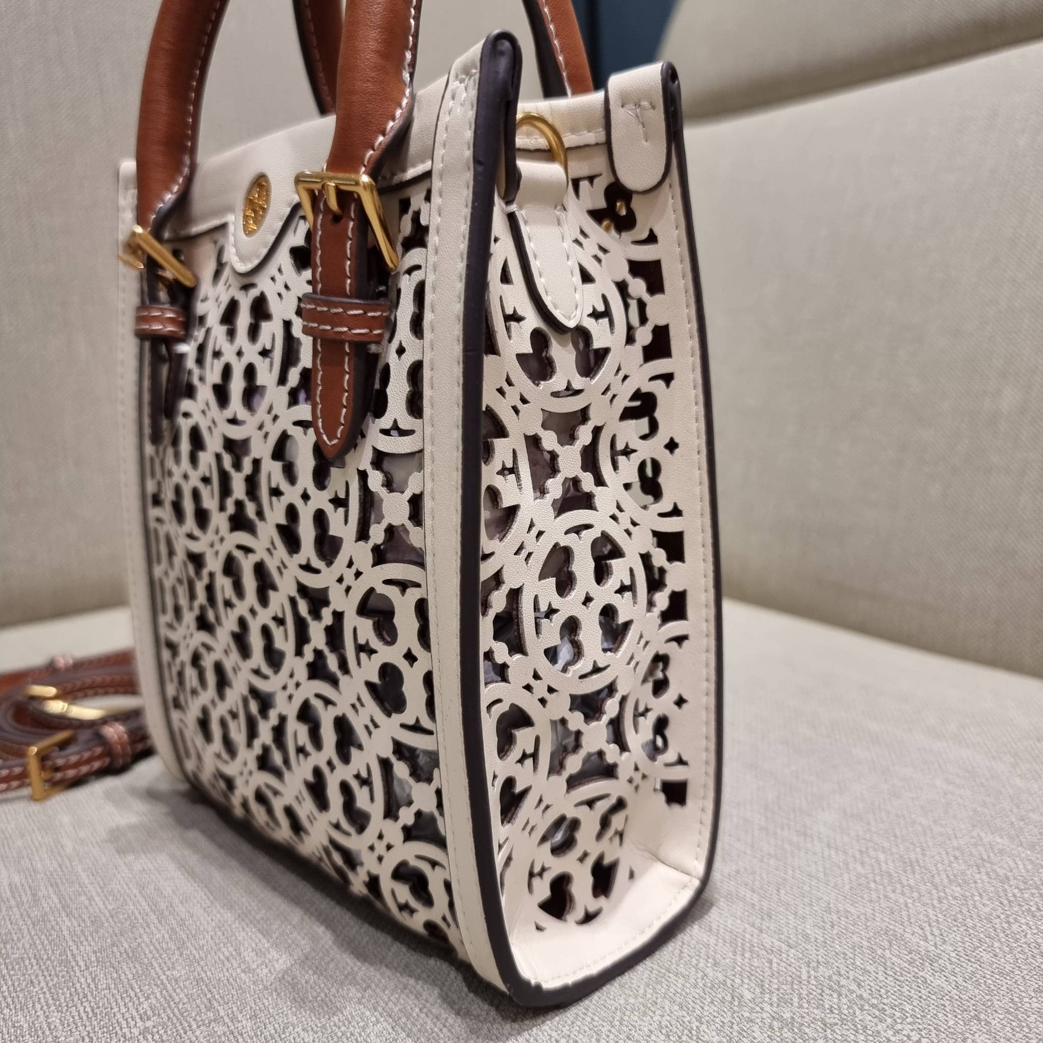 TORY BURCH T MONOGRAM LASER-CUT MINI TOTE ใจบางที่สุดกับคอลเลคชั่นนี้ กับกระเป๋าสะพายทรงโท้ท ไซส์มินิ ที่เพิ่มดีเทลความแพงด้วยการฉลุลวดลายโมโนแกรมรอบใบ ถักทอเป็นเส้นลายสานที่สวยงามมาก งานฝีมือจริงๆ วัสดุหนัง cowhide ปากกระเป๋ามีแถบแม่เหล็กกันหล่น และมีหูจ