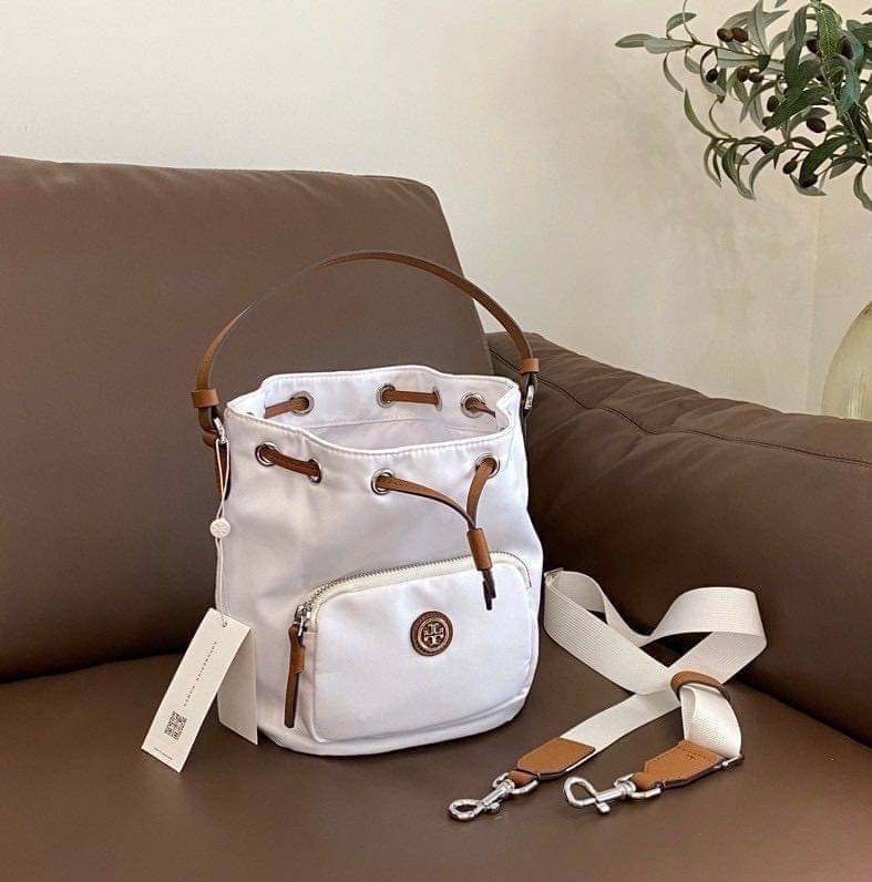 Tory Burch Virginia Nylon Bucket Bag / Tory Burch logo-plaque bucket bag กระเป๋าสะพายทรงบัคเก็ต เปิด-ปิดหนังรูดปากกระเป๋า มีหูหิ้วในตัว คล้องแขนเก๋ๆ ภายในเป็นช่องโล่ง มีช่องย่อย ใส่ของสำคัญจุกจิกได้ มีสายครอส จะสะพายไปไหนก็ได้ทุกโอกาส สวยเลิศทุกสี พร้อมส่