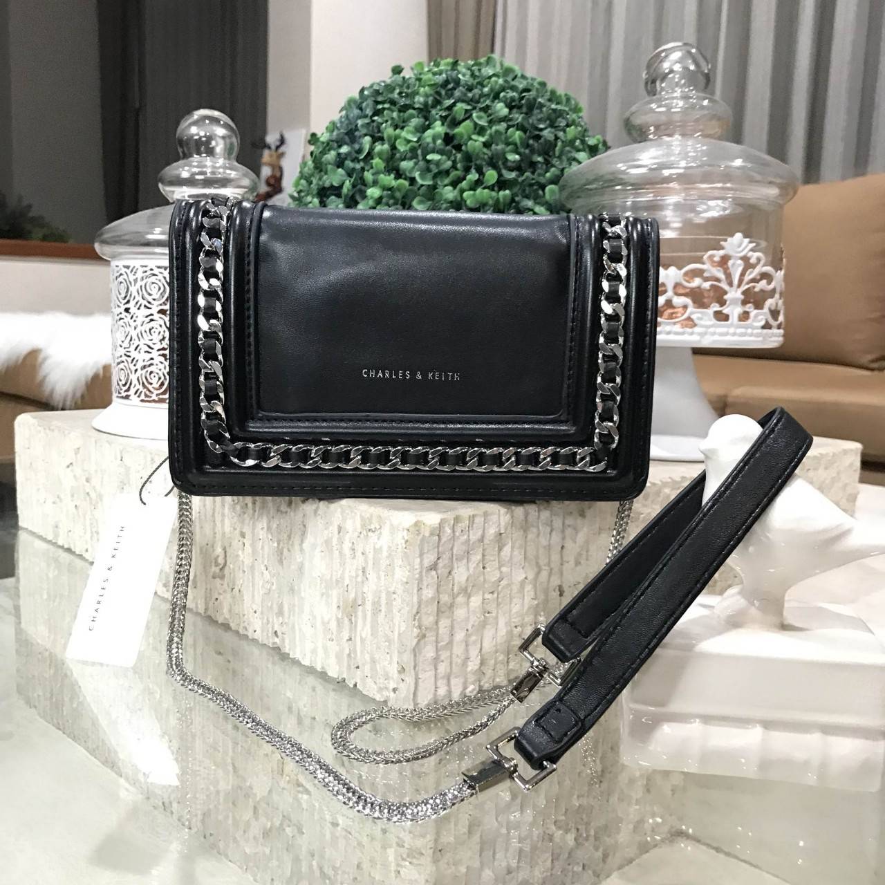 NEW ARRIVAL! CHARLES & KEITH CHAIN DETAIL CROSSBODY BAG กระเป๋าสะพายทรงสี่เหลี่ยมรุ่นชนช็อปขนาดกำลังดีวัสดุหนังนิ่มเรียบประดับด้วยโซ่ด้านหน้าดูมีดีเทล เปิดปิดด้วยกระดุมแม่เหล็ก ภายในมีช่องใส่บัตรและช่องซิป มาพร้อมสายโซ่ต่อหนังถอดถือเป็นคลัชได้ ภาพถ่ายสินค