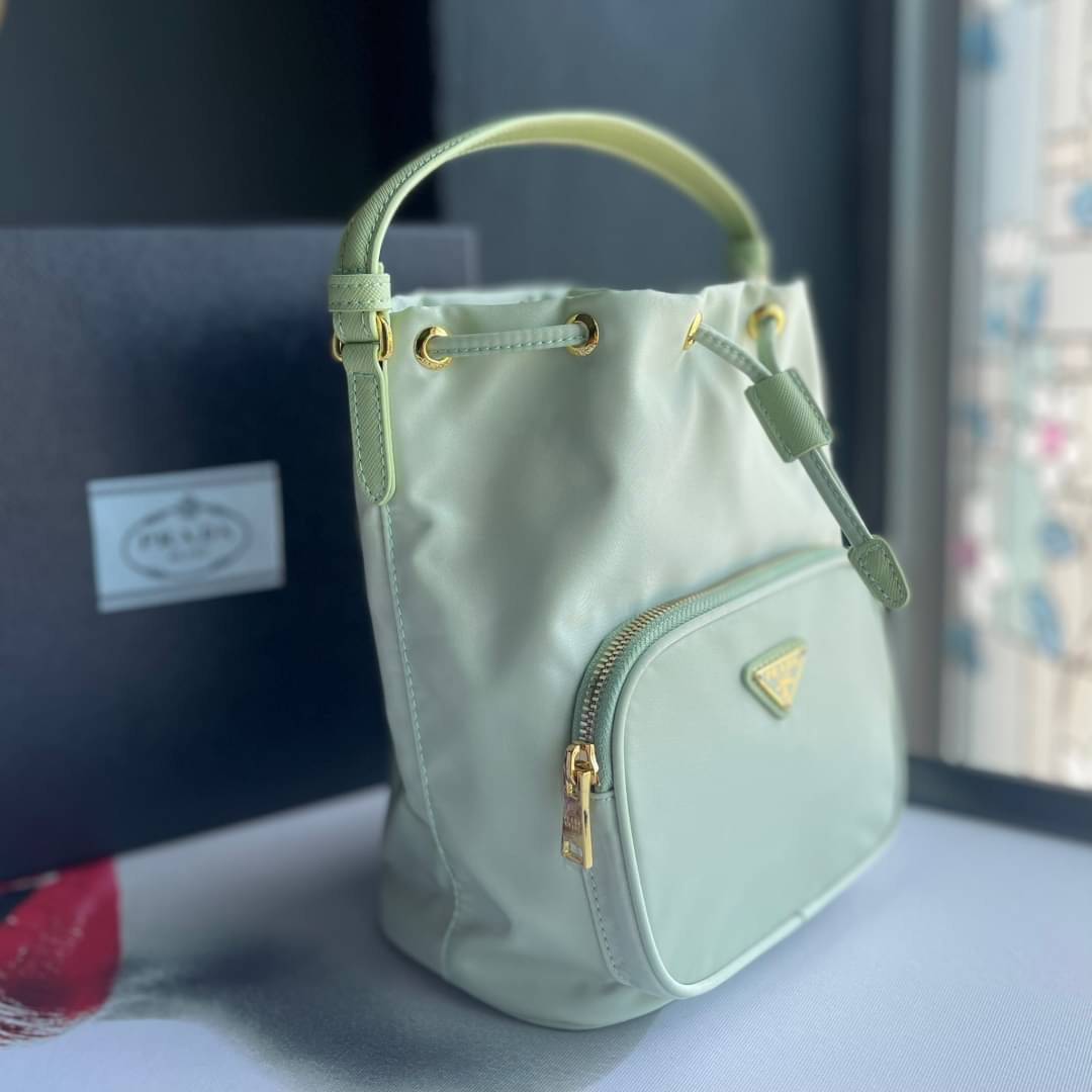 Prada Duet Re-Nylon Bucket shoulder bag / Prada Nylon bucket bag Pastel เกรดใช้สลับใบจริง ออริจินอล ใช้งานต่างประเทศได้ น้องสาวสุดสวยมาให้จับจองอีกหนึ่ง สีพาสเทลน่ารักละมุนมากๆ ค่ะ กระเป๋าสะพายข้าง ทรงขนมจีบ ไซส์มินิ ขนาดน่ารักน่าใช้มาก วัสดุขอบหนังแท้ แล