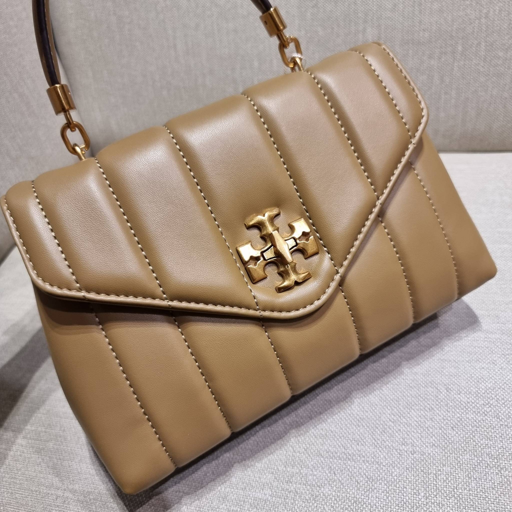 TORY BURCH KIRA QUILTED SMALL SATCHEL มาแล้วด่วนๆ!! กับคอลที่ปังไม่ไหว พร้อมเสิร์ฟสีคลาสสิค กระเป๋าถือ/สะพาย ทรงสวย สะพายคล่องตัว หนังแท้ ดีไซน์บุนวม เส้นคมสวยหรู วัสดุหนังแกะ สัมผัสดีงาม นิ่มมือ เปิด-ปิดด้วยอะไหล่บิดล็อค ภายในเป็นช่องโล่ง มีช่องซิป ใส่ขอ