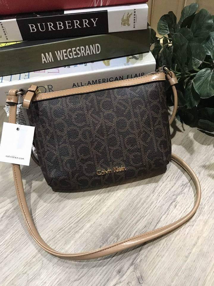 Calvin Klein Cross Body Bag กระเป๋าสะพายรุ่นใหม่ล่าสุดหนังสวย สกรีนลาย Signature แบรนด์รอบใบ ประดับโลโก้แบรนด์ สีทองด้านหน้า เปิดปิดด้วยซิป น้ำหนักเบา ภายใน โล่งกว้าง มีช่องใส่บัตร และช่องซิป ใส่ iphone+ ได้ มาพร้อมสายสะพายยาว ขนาดกำลังน่ารัก สะพายคล่องตั