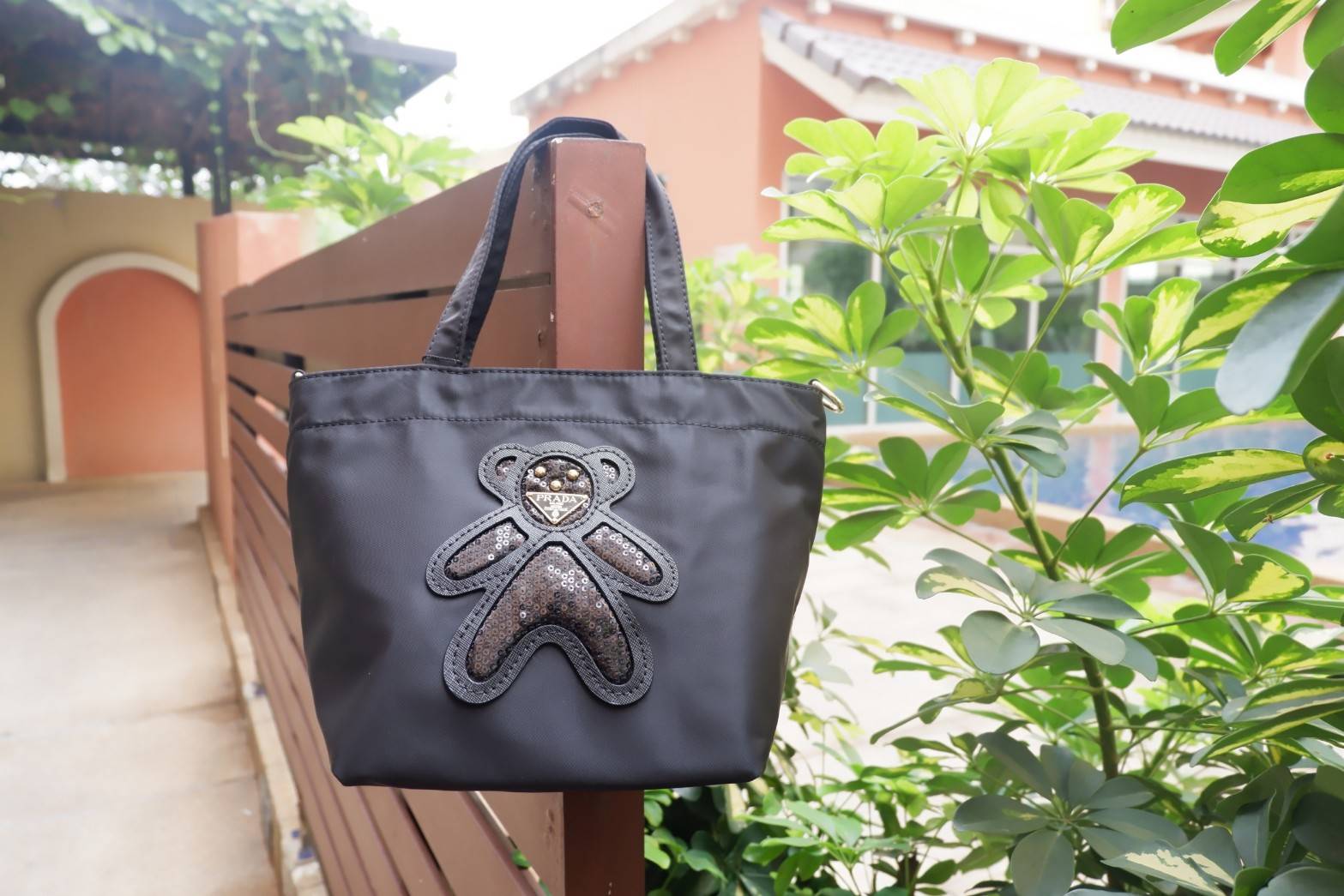 BEST SELLER !! สำหรับกระเป๋าอเนกประสงค์ ทรง Mini TOTE จากแบรนด์ PRADA เป็น กระเป๋าผ้าไนล่อน ตามแบบฉบับของแบรนด์เลย ใบนี้มีสายยาวให้ค่ะ เลิศมาก สะพายเป็น Shoulder bag หรือถือได้คะ ด้านหน้าเป็นลายหมี ปั๊กกลิ้ตเตอร์ +logo brand ใช้แล้วสวยมากๆ อะไหล่ทองหรูมาก