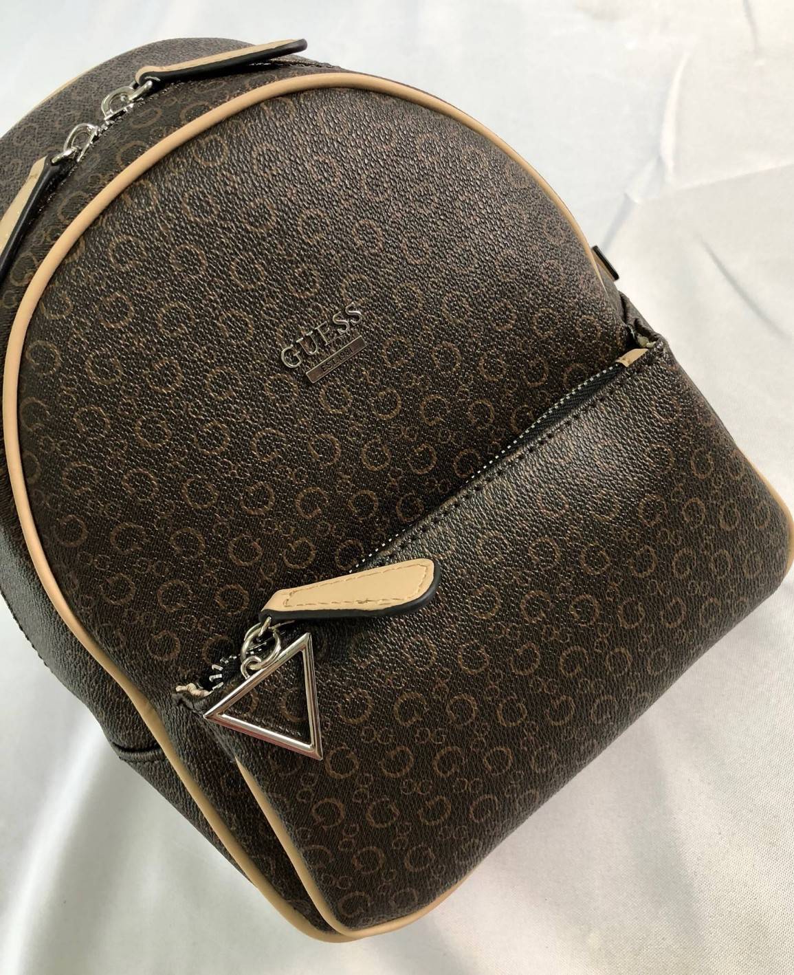 GUESS PANDORE BACKPACK กระเป๋าสะพายหลัง วัสดุหนังนิ่มมือ น้ำหนักเบา ด้านหน้ามีโลโก้แบรนด์ พร้อมช่องซิปหนึ่งช่อง ที่จับซิปมีอะไหล่สัญลักษณ์แบรนด์ ช่องซิปหลักเปิดปิดด้วยซิปคู่ ภายในโล่ง กว้าง ใส่ของได้จุ มีช่องซิปและช่องเล็กใส่ของจุกจิก สายสะพายด้านหลังเลื่