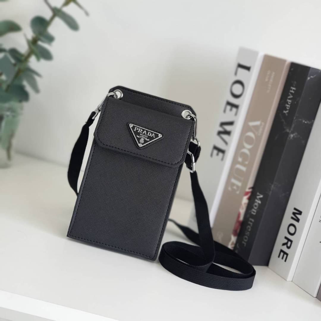 PRADA PHONE CASE ไอเท็มสุดคลาสสิคที่ทุกท่านควรมี! Prada Saffiano Leather Smartphone Case งานพรีเมี่ยมกิ้ฟท์จากเคาเตอร์ต่างประเทศ ของมีจำนวนจำกัด หนังลาย saffiano อยู่ทรงสวย ดีไซน์หรูหรา ดูดี ทรงCrossbody ด้านหน้ามีโลโก้แบรนด์ อะไหล่ทอง ด้านในเปิดปิดด้วยกร