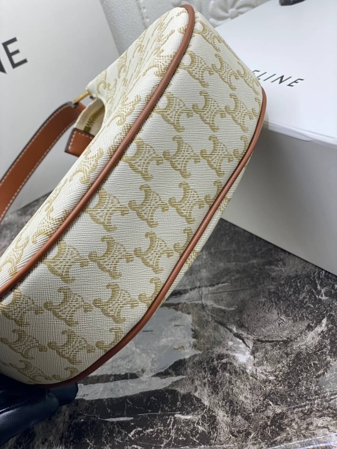 หนังแท้ CELINE AVA / CELINE Vintage Classic Ava bag 1 ใน คอลเลคชั่น “Triomphe Canvas” มาพร้อมสายสะพายไหล่ที่ปรับความยาวได้ และเนื่องจากช่วงล่างของกระเป๋ามีขนาดใหญ่กว่าช่วงบน จึงทำให้ไม่เสียทรงเมื่อเราใส่สิ่งของอย่างกระเป๋าสตางค์หรือโทรศัพท์มือถือ หากดูภาพ