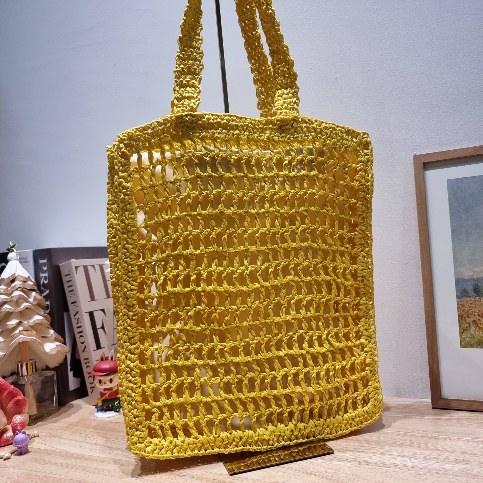 PRADA RAFFIA TOTE BAG สวยไม่ซ้ำใคร สไตล์บีช เหมาะมากกับการสะพายไปเที่ยวทะเล หรือจะใช้ในวันสบายๆก็ตอบโจทย์ กับกระเป๋าสะพายสานใบใหญ่ ตัวกระเป๋าเป็นวัสดุสังเคราห์จากธรรมชาติ