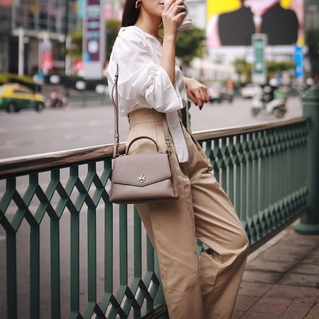 TORY BURCH KIRA MIXED-MATERIALS TOP-HANDLE SATCHEL กระเป๋าสะพายข้าง วัสดุหนังแกะสังเคราะห์ อะไหล่ทอง ด้านหน้าประดับโลโก้แบรนด์ ตกแต่งสายโซ่ห้อยสีทอง (สามารถถอดออกได้) เปิด-ปิดด้วยตัวล็อคหมุน ภายในโล่งกว้าง ซับในบุผ้าลายแบรนด์ แบ่งออกเป็น 3 ช่องใหญ่ พร้อมช