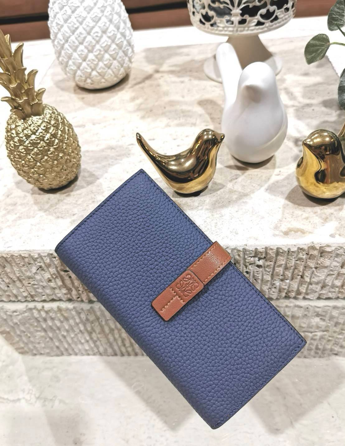 LOEWE LONG WALLET BAG วัสดุหนังแท้เทคเจอร์สวยอยู่ทรงปั้มโลโก้แบรนด์ด้านหน้าเปิดปิดด้วยกระดุม ภายในมีช่องใส่ธนบัตรหลายช่อง ช่องหลักสามารถใส่มือถือได้ มีช่องซิปใส่เหรียญ ช่องใส่ธนบัตรใส่แบงก์พันได้ สวยน่าใช้ พร้อมส่งที่ไทยสุดคุ้มห้ามพลาด!