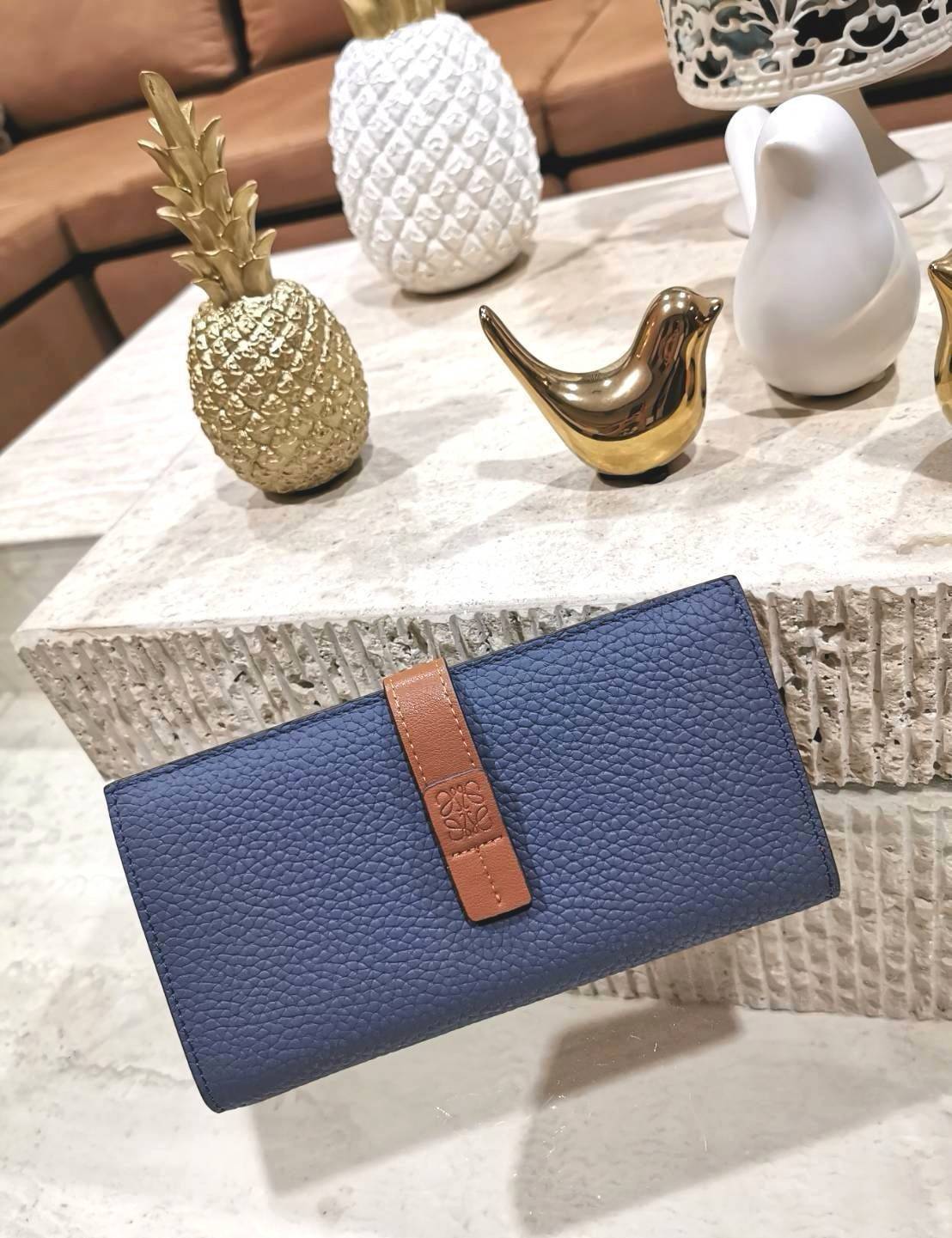 LOEWE LONG WALLET BAG วัสดุหนังแท้เทคเจอร์สวยอยู่ทรงปั้มโลโก้แบรนด์ด้านหน้าเปิดปิดด้วยกระดุม ภายในมีช่องใส่ธนบัตรหลายช่อง ช่องหลักสามารถใส่มือถือได้ มีช่องซิปใส่เหรียญ ช่องใส่ธนบัตรใส่แบงก์พันได้ สวยน่าใช้ พร้อมส่งที่ไทยสุดคุ้มห้ามพลาด!