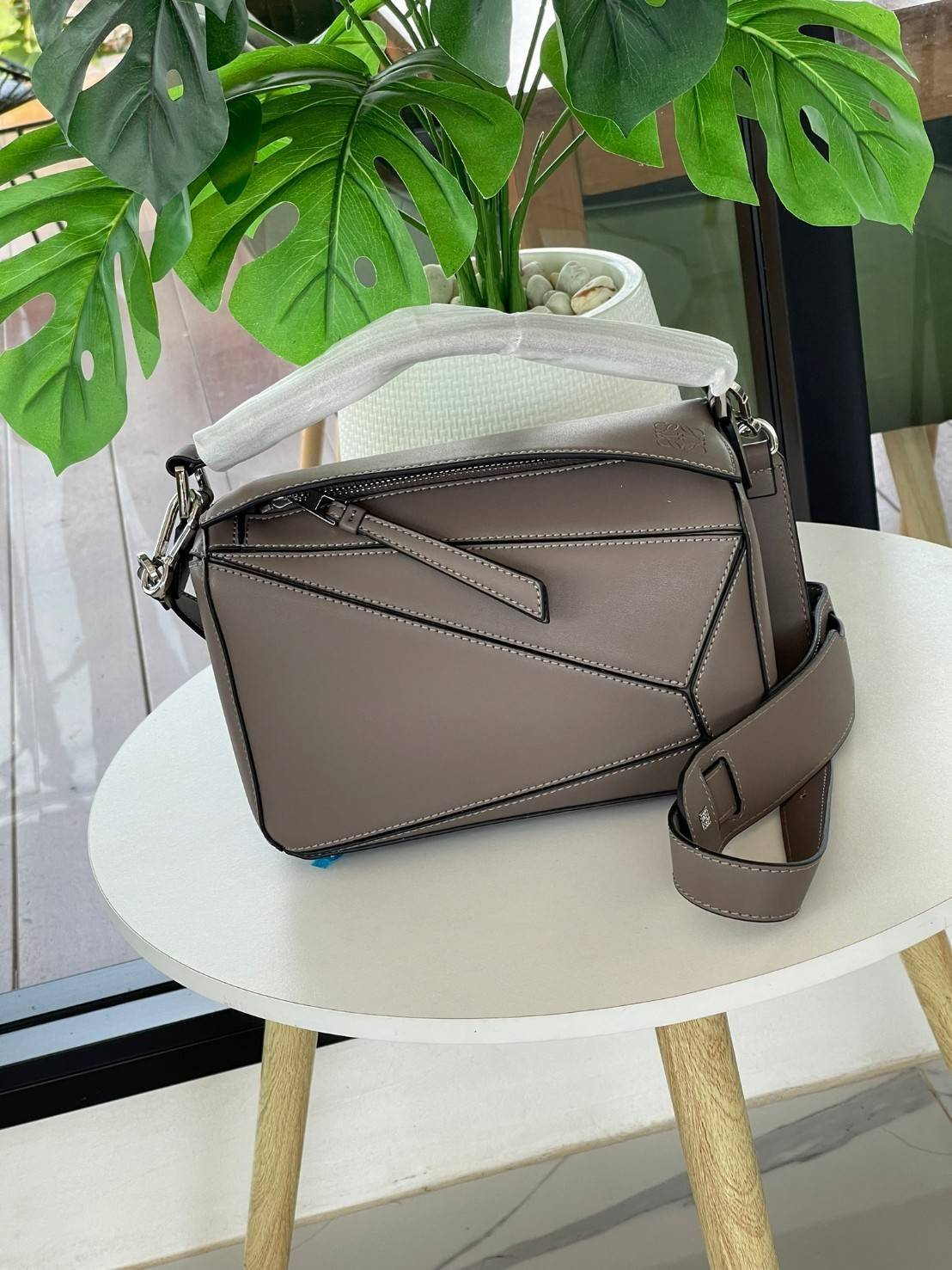 Loewe Puzzle Bag In Classic กระเป๋าทรง Puzzle นี้ออกแบบโดย Jonathan Anderson โดยได้รับแรงบันดาลใจในการออกแบบมาจากรูปทรงของลูกรักบี้ ดังนั้น จึงจะเห็นได้ว่าการตัดเย็บและรูปทรงของกระเป๋านั้นคล้ายคลึงกับลูกรักบี้ รูปทรงดูมินิมอลไม่ทิ้งคอนเซ็ปต์ของแบรนด์ สามา