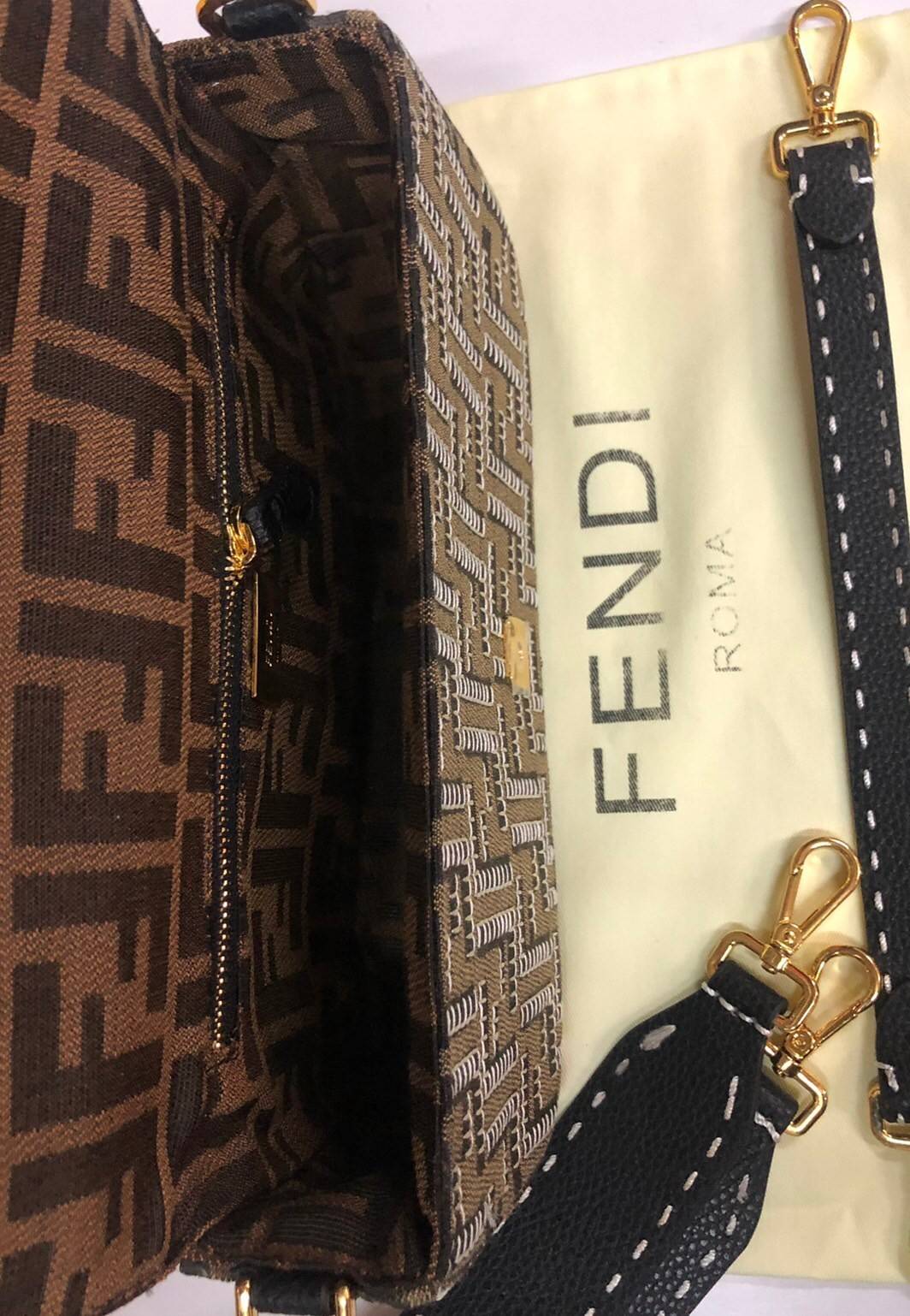 หนังแท้ Fendi Embroidered FF fabric bag กระเป๋าบาแกตต์ขนาดกลางอันเป็นเอกลักษณ์ ผลิตจากผ้าแจ็คการ์ดพร้อมลวดลาย FF สีน้ำตาลอันเป็นเอกลักษณ์ ตกแต่งด้วยงานปักสีตัดกัน ตกแต่งด้วยตัวล็อค FF โดดเด่นด้วยฝาปิดด้านหน้า ตัวล็อคแบบแม่เหล็ก ขอบหนัง