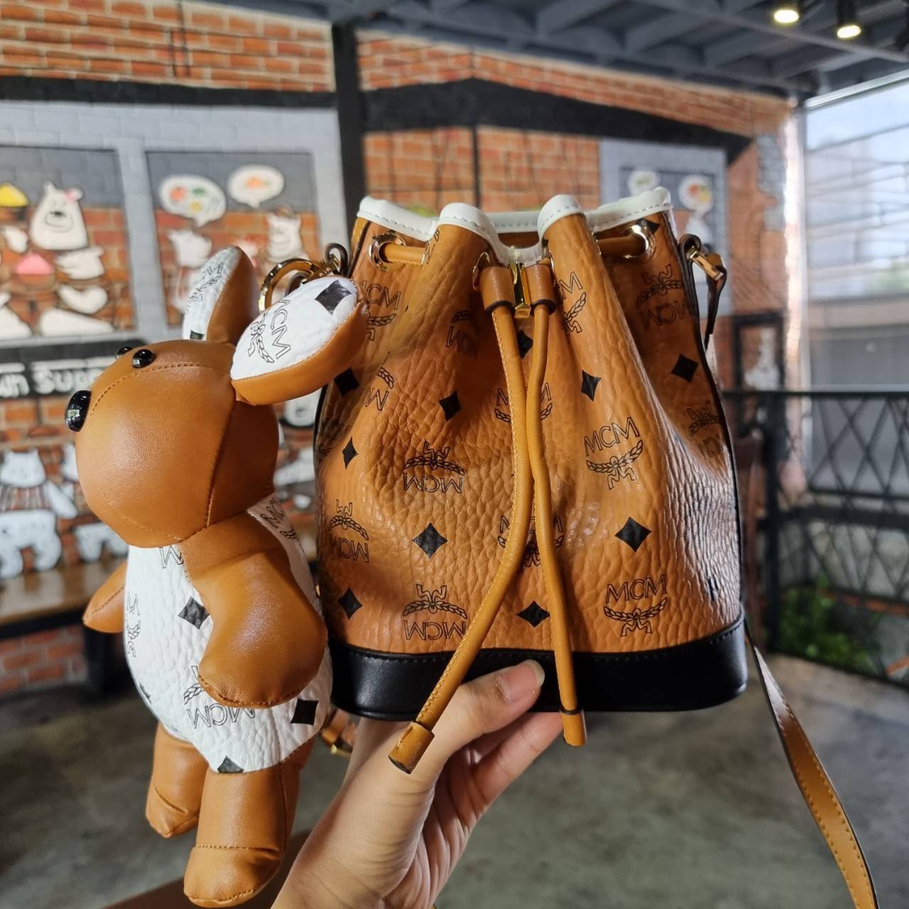 M.C.M ZOO RABBIT DRAWSTRING BAG IN VISETOS LEATHER MIX คอลเลคชั่นซูมาใหม่ ฮิตหนักมากที่เกาหลีและญี่ปุ่น ไอเท็มสุดคิ้วท์ น้องกระะต่ายโดดเด่น กระเป๋าสะพายทรง bucket ไซส์เล็กขนาดน่ารักน่าใช้ แฟชั่นสไตล์มากใบนี้ ดีไซน์น้องกระต่ายแอบในกระเป๋า และสามารถนำออกมาห