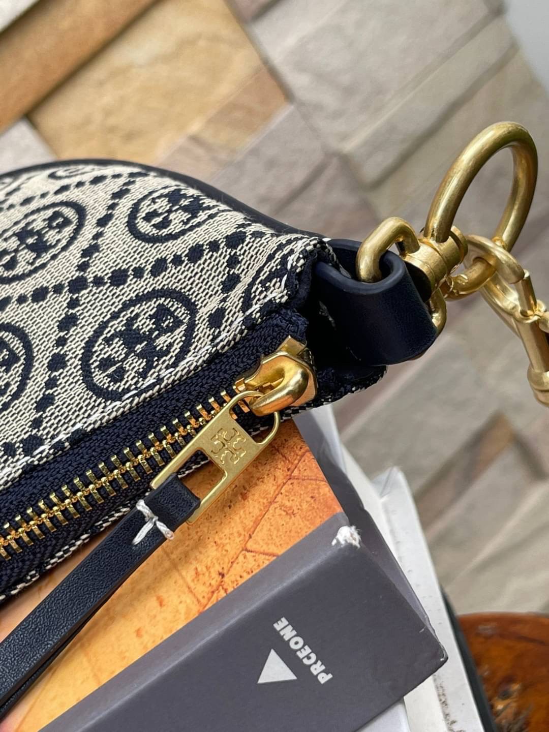 ของแท้ 💯% Tory Burch T monogram jacquard Mini Hobo Bag กระเป๋าลวดลาย T Monogram ใบนี้มาในรูปแบบกระเป๋าทรง Hobo Bag มีความแตกต่างจากกระเป๋าทรงอื่นๆ