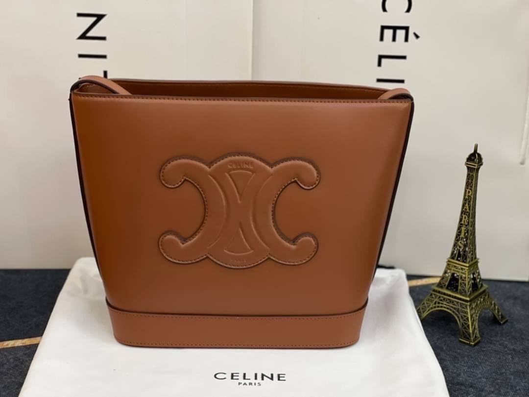 หนังแท้ CELINE SMALL BUCKET CUIR TRIOMPHE IN SMOOTH CALFSKIN / CELINE BUCKET BAG CUIR TRIOMPHE พร้อมส่งที่ไทย คอลเลคชั่นใหม่ ฮิตข้ามปี กับกระเป๋าสะพายทรงถัง ใช้งานง่ายที่สุด สายสะพายในตัว ปรับใช้ได้เลย วัสดุหนังวัว เรียบหรู ผู้ดีไปอีก โดดเด่นด้วยโลโก้เอกล