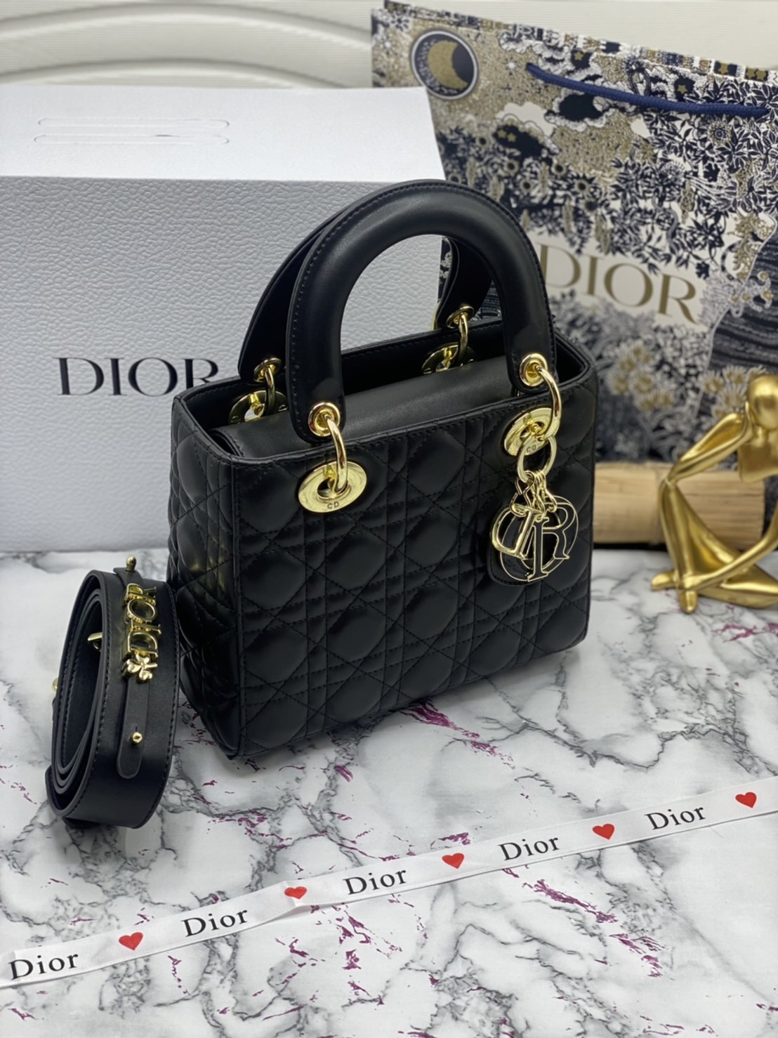 หนังแท้ DIOR LADY BAG 20cm ความสง่างามอีกหนึ่งรุ่นของ Dior รูปทรงสีเหลียม ขนาดกระทัดรัด ตั้งอยู่ทรง ฐานกระเป๋าแข็งแรง มีหมุดรองฐาน ดีไซน์ที่มีเอกลักษณ์เฉพาะตัว ด้านหน้าตกแต่งด้วยตัวอักษร D.I.R ห้อยเป็นพวงกุญแจ จะถือด้วยมือหรือสะพายไหล่ก็ดูดีมากๆ ค่ะ