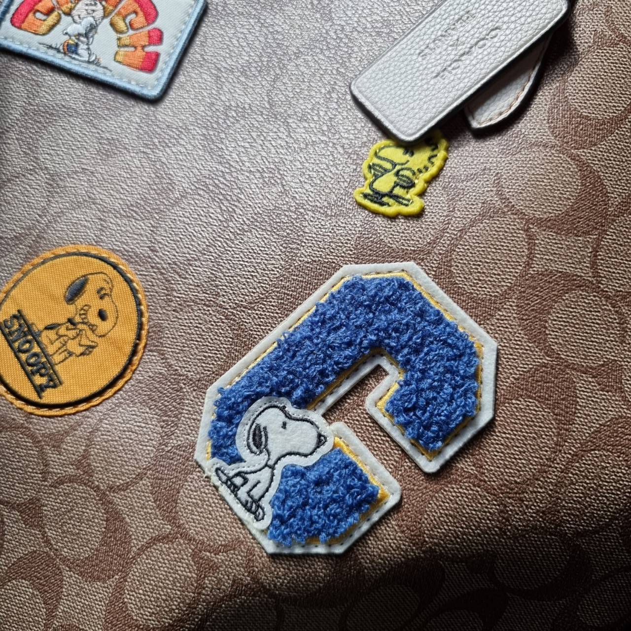 COACH C4292 COACHxPEANUTS CITY TOTE IN SIGNATURE CANVAS WITH VARSITY PATCHES กระเป๋าทรงโท้ทใบใหญ่ กับคอลเลคชั่นคอลแลบใหม่ล่าสุด น่ารักด้วยเหล่าผองเพื่อนสนู้ปพี สวยโดดเด่นมากๆ ใบนี้ใส่ของได้ของครบครัน จุได้แบบไม่ต้องกลัวเต็ม!! วัสดุหนังแคนวาสคุณภาพดี ปากกร