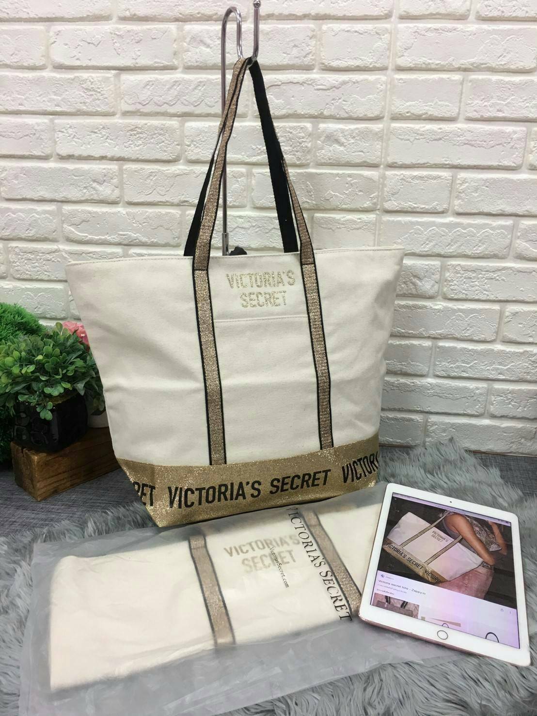 Victoria's Secret Canvas Tote Bag กระเป๋าสะพายวัสดุแคสวาสสีครีม ด้านล่างเป็นกลิตเตอร์ สกรีนชื่อแบรนด์ ฐานกระเป๋าเป็นหนัง ด้านหน้ามีช่องเล็กไว้ใส่ของได้ เปิดปิดด้วยซิป ซับในลายแบรนด์ มีช่องซิปเล็กแยกใส่ของ1ช่อง จุของได้เยอะมาก