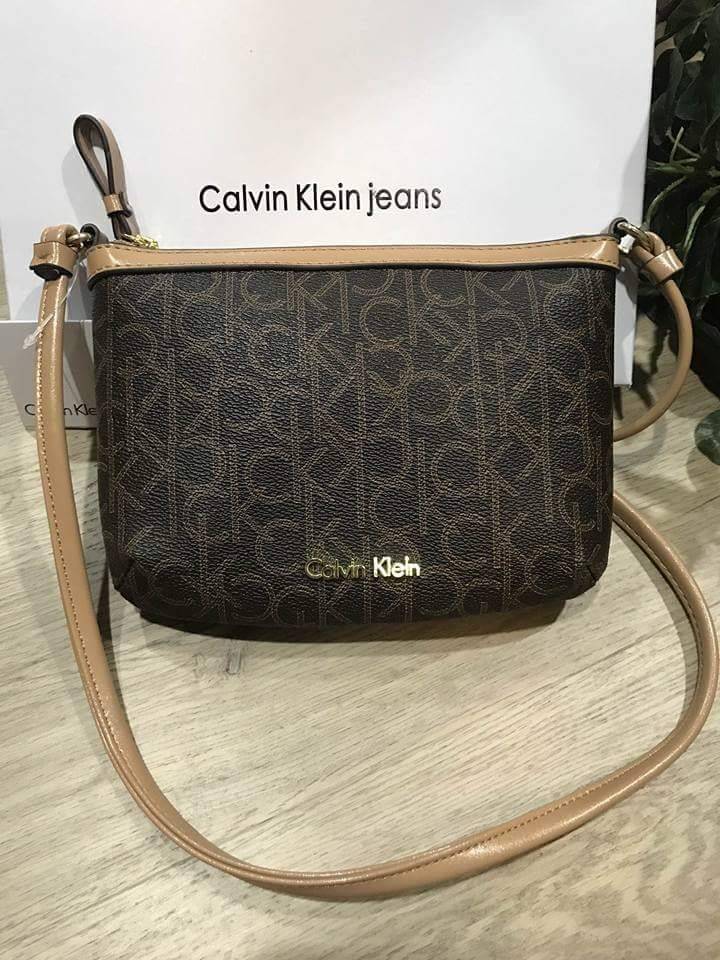 Calvin Klein Cross Body Bag กระเป๋าสะพายรุ่นใหม่ล่าสุดหนังสวย สกรีนลาย Signature แบรนด์รอบใบ ประดับโลโก้แบรนด์ สีทองด้านหน้า เปิดปิดด้วยซิป น้ำหนักเบา ภายใน โล่งกว้าง มีช่องใส่บัตร และช่องซิป ใส่ iphone+ ได้ มาพร้อมสายสะพายยาว ขนาดกำลังน่ารัก สะพายคล่องตั