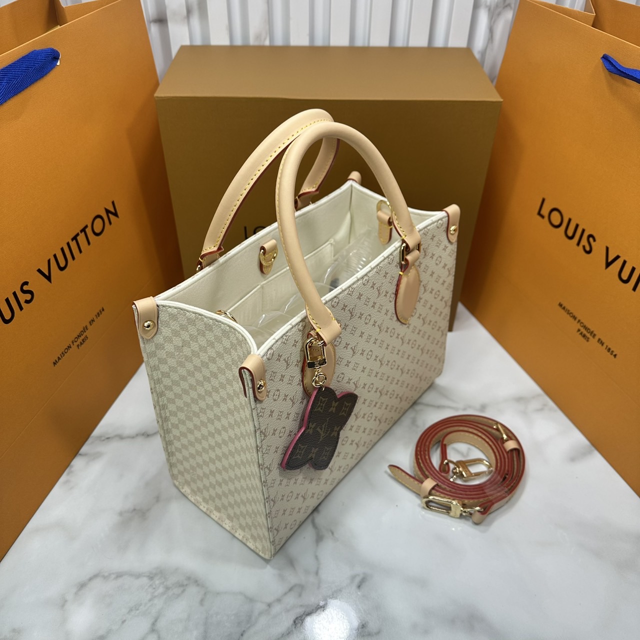 ORI หนังแท้ | LV OnTheGo PM bag Monogram Sand Beige กระเป๋าสะพายทรงโท้ทออนเดอะโก ในคอลเลกชัน LV Romance ยกระดับดีไซน์สำหรับฤดูกาลนี้ด้วยการผสานสัญลักษณ์ไอคอนิกลาย Damier และ Monogram ที่มีเอกลักษณ์ไม่ซ้ำใครของเมซงเข้าด้วยกัน กระเป๋าถือหนังหรูหรา