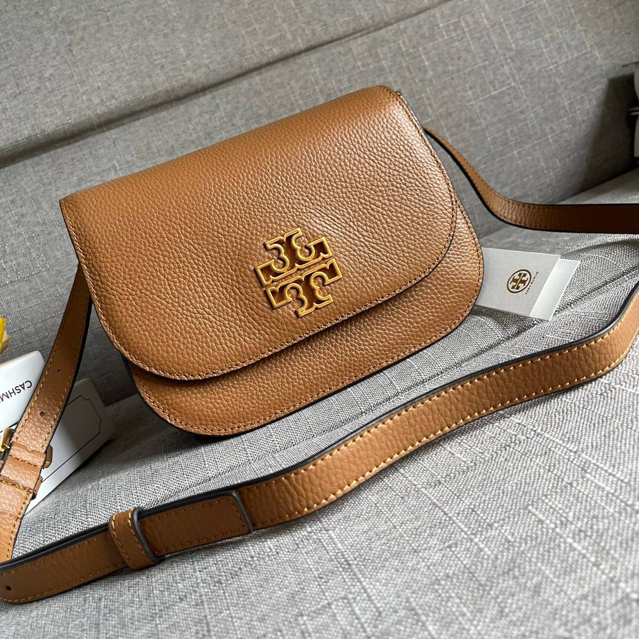 TORY BURCH BRLTTEN SMALL SADDLE BAG / Tory Burch Britten Flap Shoulder Bag กระเป๋าสะพายข้าง วัสดุหนังแกะแท้ ด้านหน้าประดับโลโก้แบรนด์ เปิด-ปิดกระเป๋าแบบกระดุมแป็กแม่เหล็กแน่นหนา ภายในมีช่องหลัก ใส่กระเป๋าเงินใบกลาง มือถือได้ทุกรุ่น มีช่องแยกใส่ของจุกจิกอี