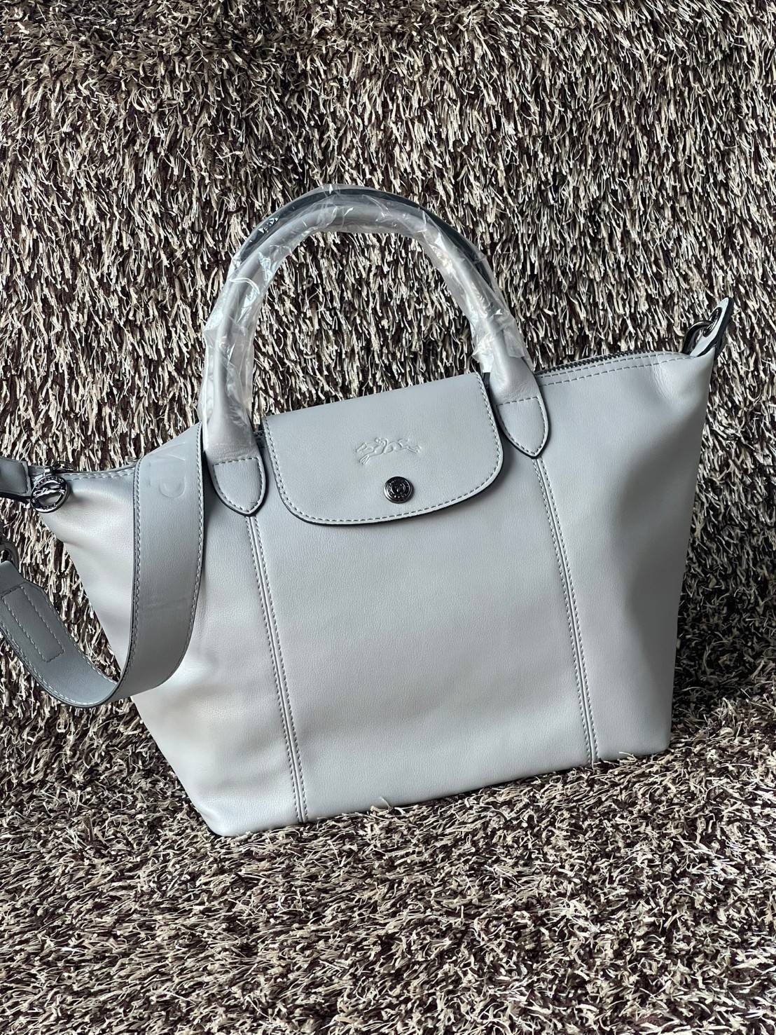 Longchamp Le Pliage Cuir Top handle bag S เรียกว่าเป็นกระเป๋าอีกหนึ่งรุ่นที่ไม่ว่ายังไงก็ฮอตฮิตและติดเทรนด์ตลอดไม่เคยเปลี่ยนกับ ทรง Le Pliage Cuir หนึ่งในตระกูลกระเป๋าสุดไอคอนิกจากแบรนด์