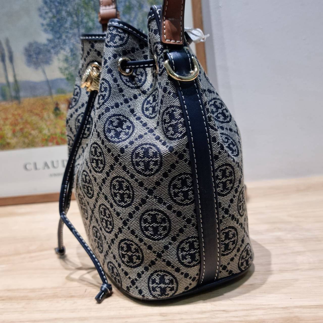 TOP ORI หนังแท้ | เกรดดีสุด TORY BURCH T MONOGRAM BUCKET BAG (ดีไซน์ใหม่) ใหม่ล่าสุดได้สวยก่อนใคร กับกระเป๋าบัคเก็ตยอดฮิต ที่มาในดีไซน์ใหม่ สายคล้องในตัวสามารถปรับได้ รูปทรงและลวดลายสวยชัดคลาสสิค