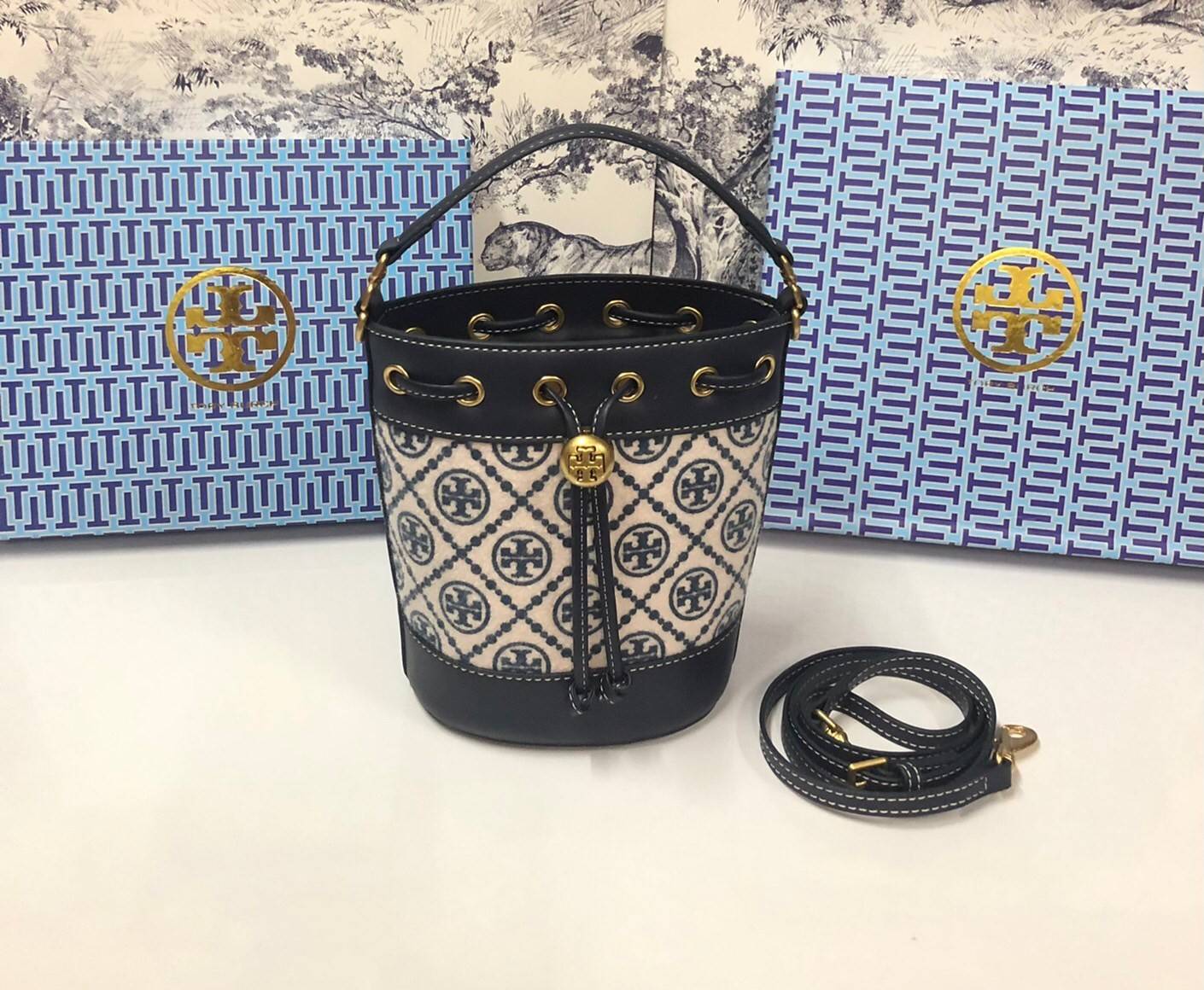 Mini : Tory Burch T Monogram Chenille Bucket Bag เปิดตัวอีกหนึ่งรุ่นกับกระเป๋าลาย T MONOGRAM รุ่นใหม่ล่าสุดจาก TORY BURCH พลาดไม่ได้กับโลโก้สุดคลาสสิก ลวดลาย T Monogram คือวัสดุ chenille หรือที่เรียกว่า ด้านไหมกำมะหยี่ มารังสรรค์ลงบนกระเป๋าBucketใบนี้ เป็
