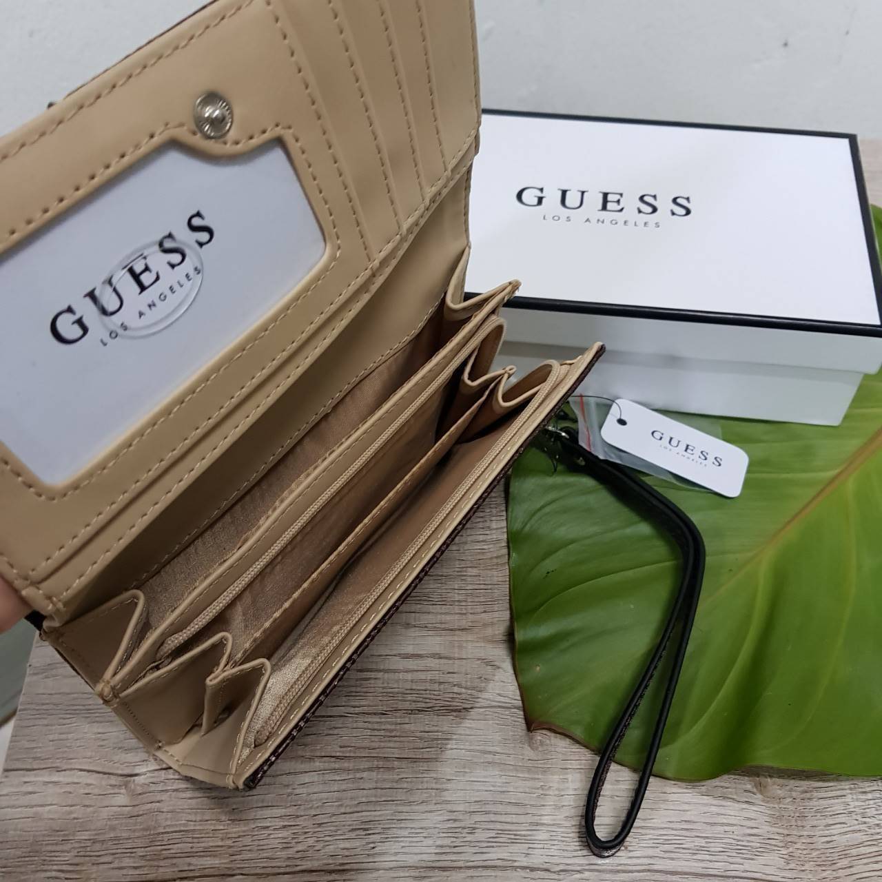 Guess leather wallet กระเป๋าสตางค์ใบกลาง มีสายคล้องมือสามารถถอดได้ ด้านหน้าแต่งโลโก้แบรนด์โลหะสีเงิน ภายในมีช่องใส่ธนบัตร,เหรียญ บัตรต่างๆ ปิดเปิดใช้งานสะดวก
