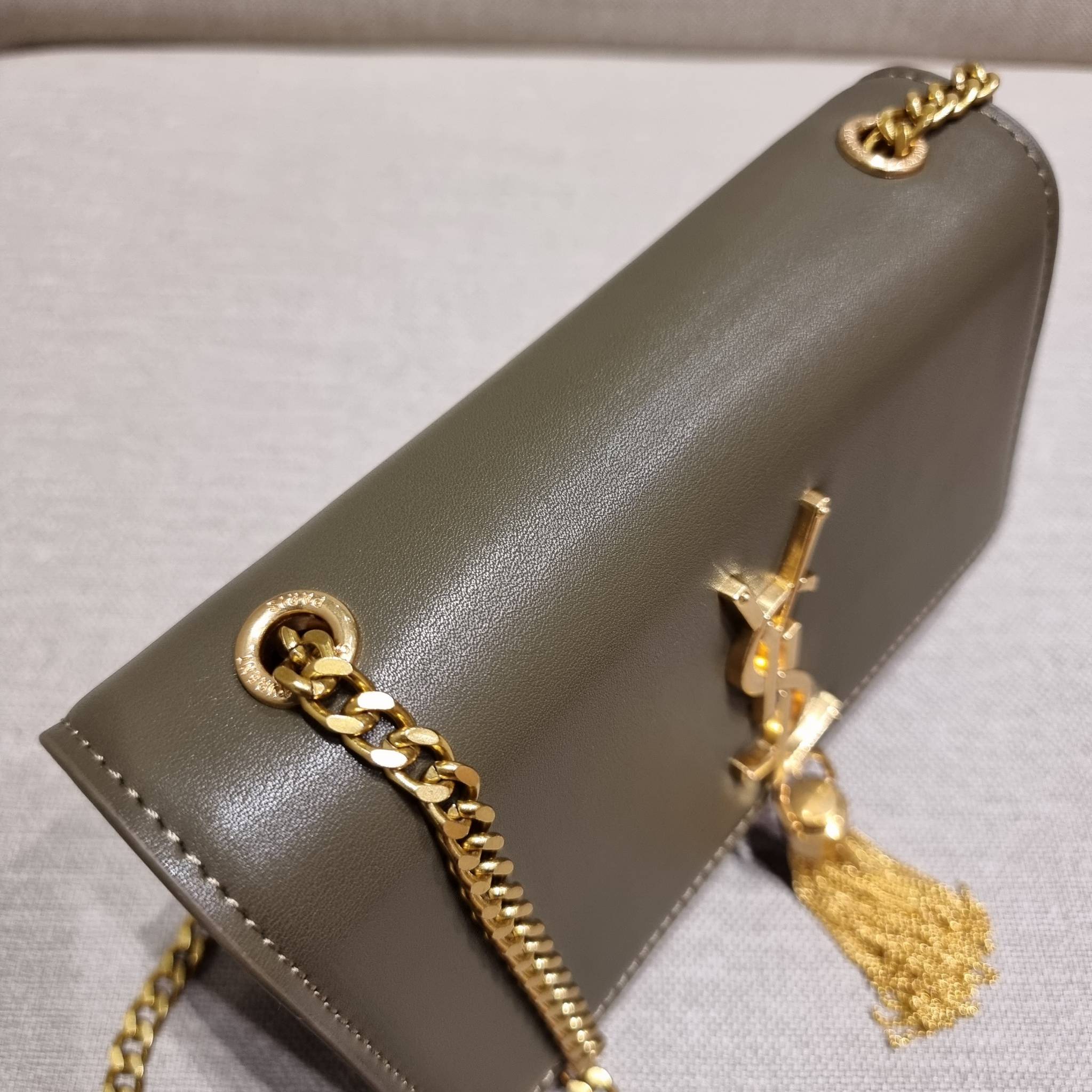 Yves Saint laurent small kate bag สุดหรู ทรง woc ที่แสนจะฮอตปรอทแตก ดีไซน์เรียบ แต่แอบมีดีเทลความหรูที่พู่ห้อยสีทองโดดเด่น เพิ่มความแพงอีกหนึ่ง วัสดุหนังแท้สัมผัสดีงาม ใช้งานง่ายเพียงแค่เปิด-ปิดด้วยกระดุมแม่เหล็ก ภายในเป็นช่องโล่ง มีช่องใส่บัตร ใส่มือถือ 