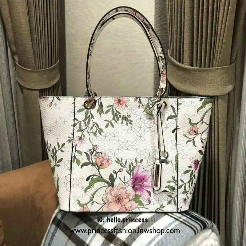 GUESS PRINTED KAMRYN FLOWERS SHOPPER BAG (SIZE L) กระเป๋าสะพายจาก GUESS FACTORY หนังสวยอยู่ทรงปริ้นลายดอกไม้คอลเลคชั่นล่าสุดใบใหญ่กำลังดี ใส่สัมภาระได้จุใจ น้ำหนักเบา ด้านหน้าประดับโลโก้แบรนด์อะไหล่เงินพร้อมพวงกุญแจแบรนด์ห้อยที่หูหิ้วถอดเเยกใช้ได้ หูหิ้วพ
