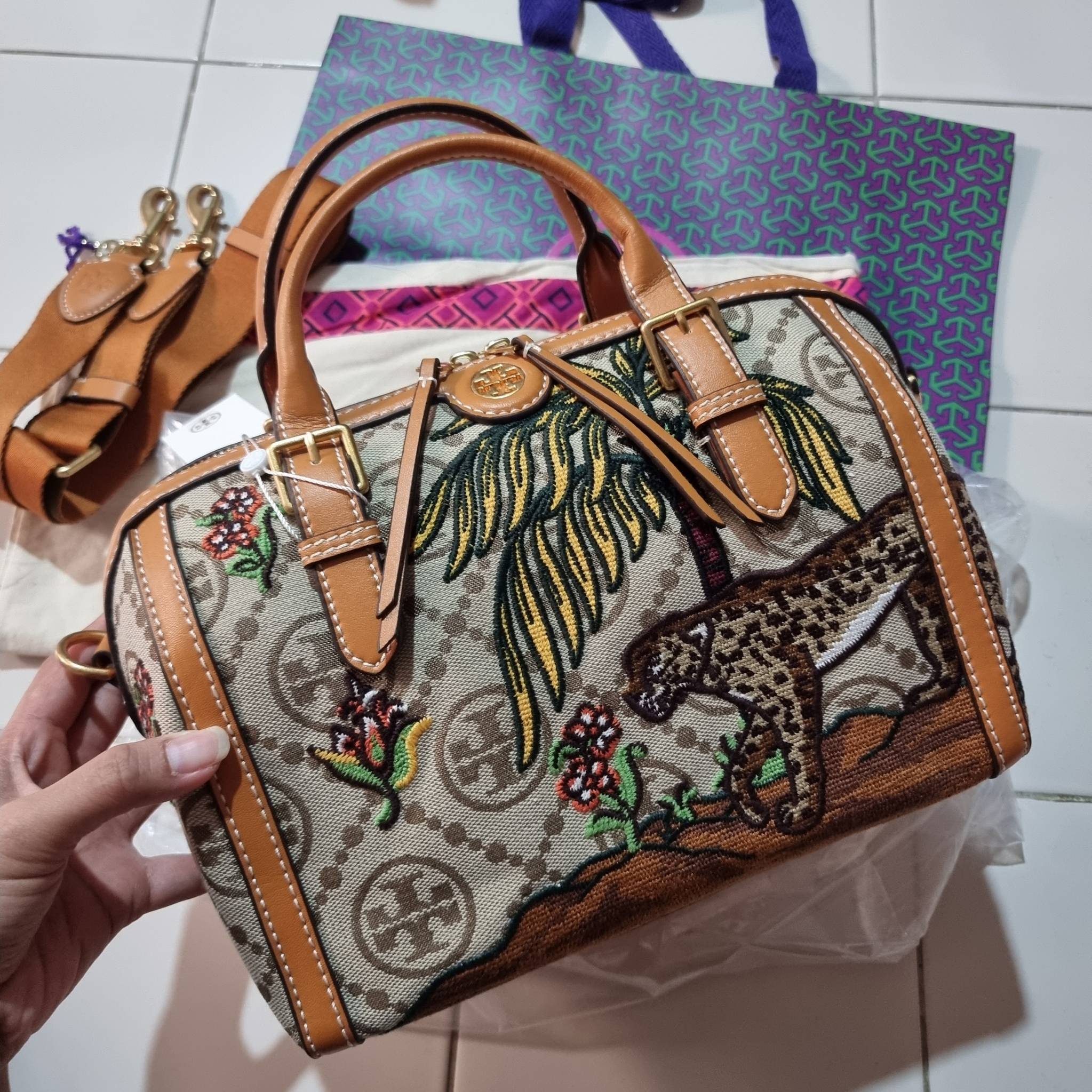 TORY BURCH T MONOGRAM JACQUARD EMBROIDERED DUFFLE คอลใหม่ล่าสุด สวยพร้อมเสิร์ฟแบบไม่ต้องรอพรีฯ ลายโมโนแกรมสุดคลาสสิคที่ถูกดีไซน์รังสรรค์ด้วยงานปักสุดชิค น่าใช้ใจฟูแค่แรกเห็น!! วัสดุ jacquard woven สลับหนังแท้ หูจับในตัว และพร้อมไปเลยกับสายสะพายข้าง ที่จะถ