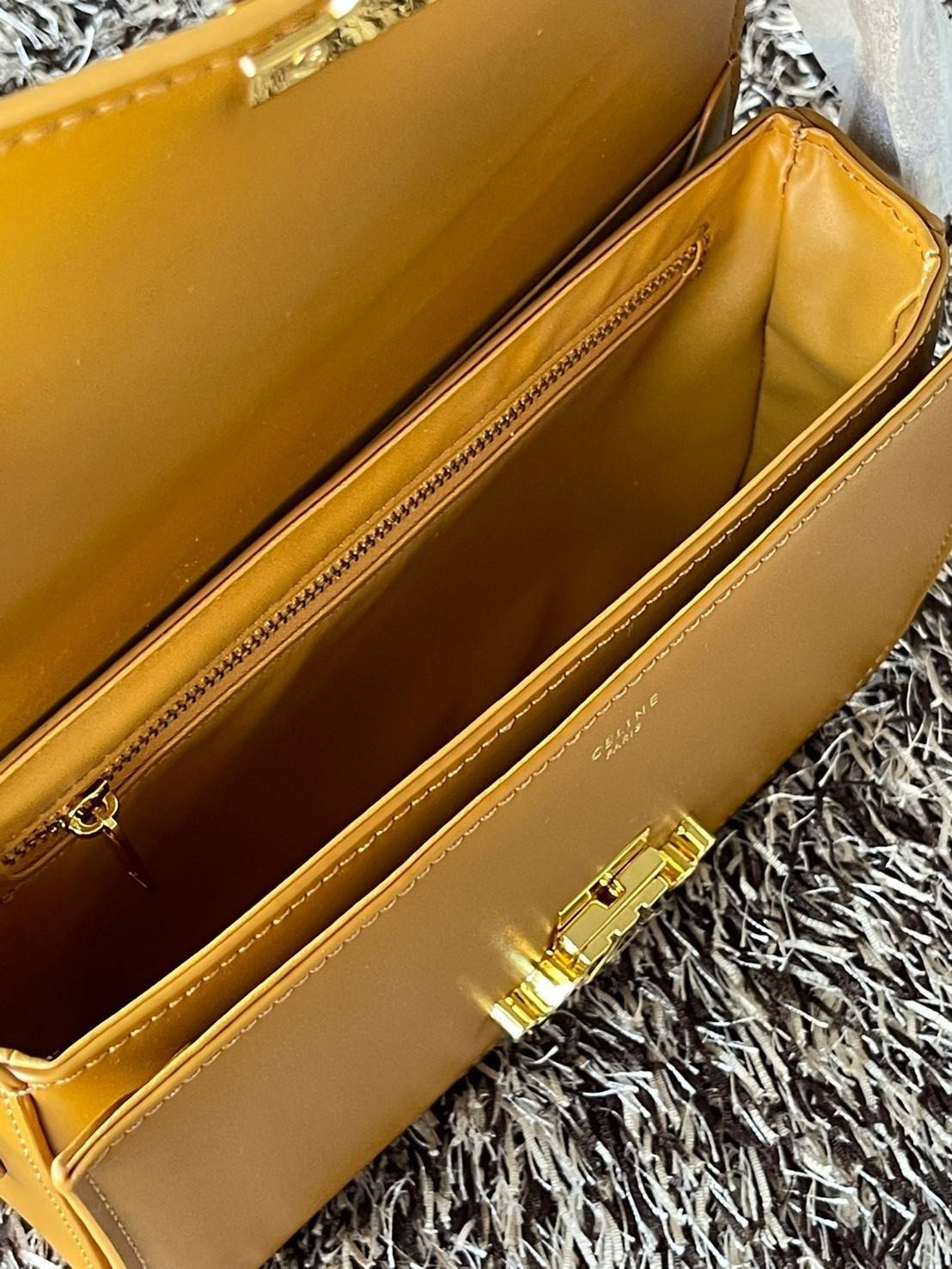 Celine MEDIUM TRIOMPHE BAG IN SHINY มีรูปทรงเป็นกล่องคล้ายกับกระเป๋า Classic Box แต่มีการออกแบบโลโก้ที่สะดุดตาแบบวินเทจ ด้วยดีไซน์ที่ดูโฉบเฉี่ยว แต่คงความคลาสสิคอย่างเต็มเปี่ยม ทำให้เป็นที่ดึงดูดความสนใจของสาวๆ สายสะพายสามารถปรับระดับได้ มีความคล่องตัวในก