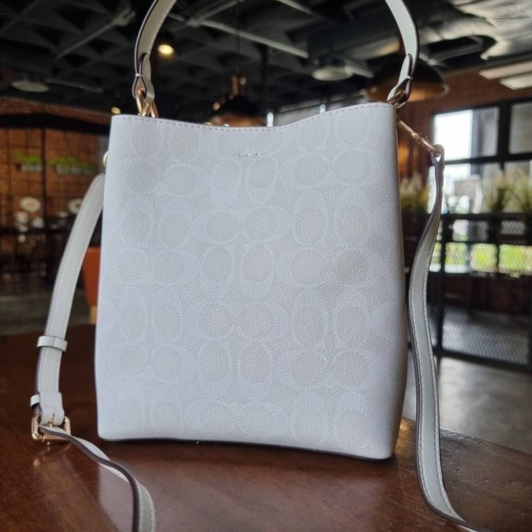 COACH 2312 SMALL TOWN BUCKET BAG IN SIGNATURE CANVAS รุ่นยอดนิยมใบเล็กมาครบสีแล้วจ้า กระเป๋าทรงบัคเก็ต สีผู้ดี๊ผู้ดี ตัวกระเป๋าดีไซน์คลาสสิคลายซี ดูโดดเด่น วัสดุหนังแคนวาสเคลือบลาย สวยคมทุกมุมจริงๆ!! เปิด-ปิดด้วยกระดุมแม่เหล็กทั้ง 2 ฝั่ง ภายในเป็นช่องโล่ง