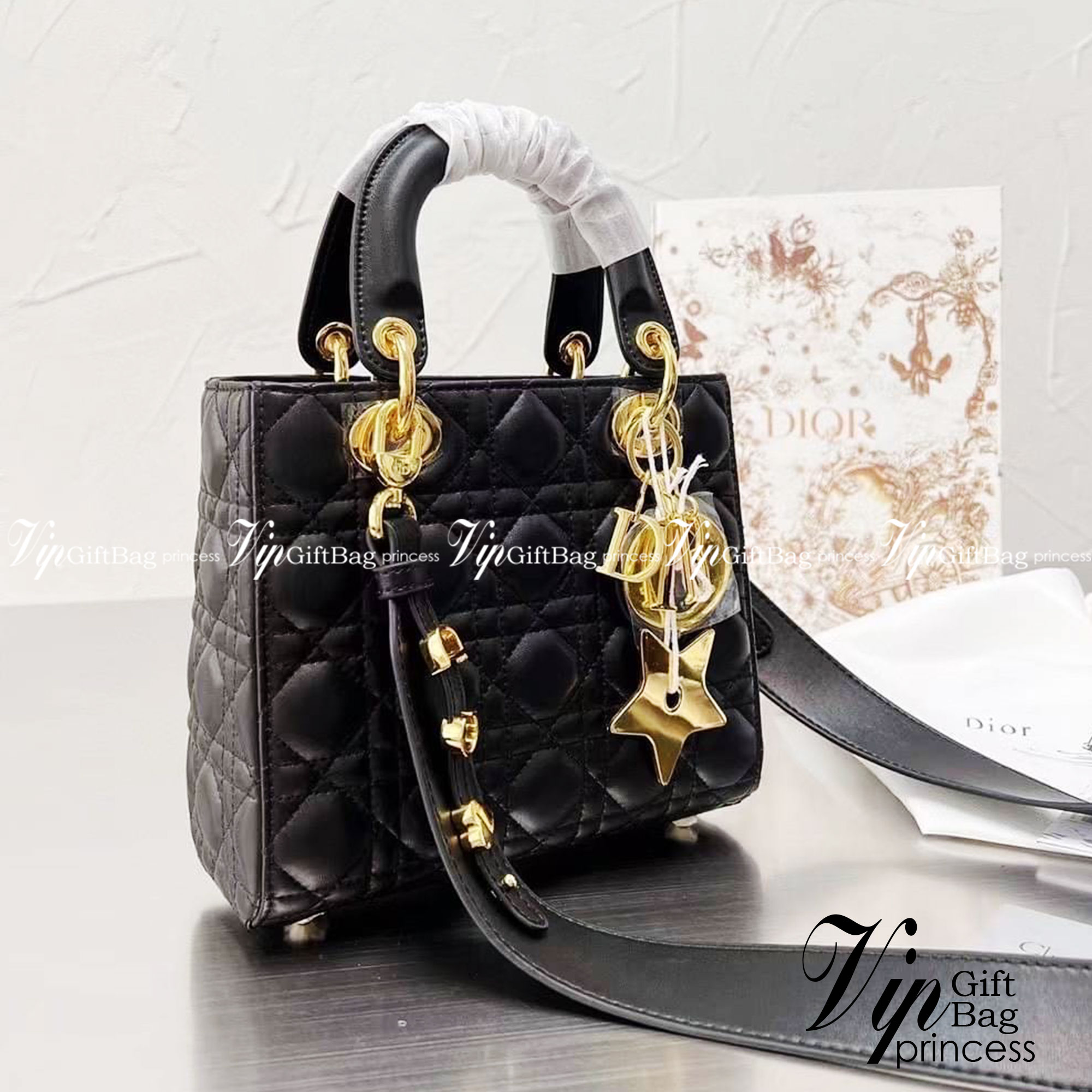 DIOR Lady / Small Lady Dior Bag Cannage Lambskin กระเป๋าสุดไอคอนิก รูปทรงสีเหลียม ขนาดกระทัดรัด ตั้งอยู่ทรง ฐานกระเป๋าแข็งแรง มีหมุดรองฐาน ดีไซน์เอกลักษณ์เฉพาะตัว ด้านหน้าตกแต่งด้วยตัวอักษร D.I.R ห้อยเป็นพวงกุญแจ จะถือหรือสะพายไหล่ก็ดูดีมากๆ ค่ะ