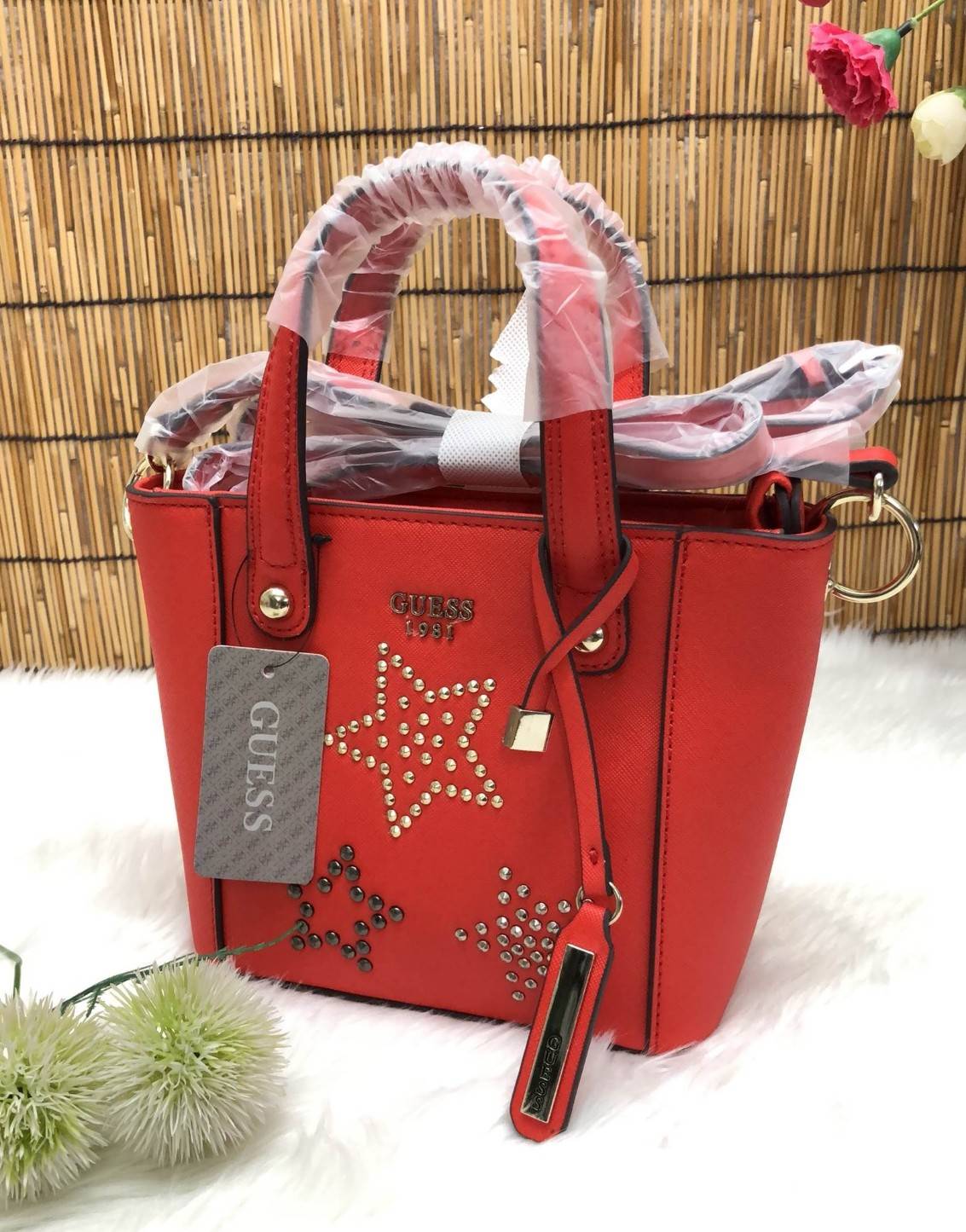 GUESS DELANEY MINI CROSSBODY BAG กระเป๋าถือหรือสะพายข้างได้ วัสดุหนังลาย saffiano ด้านหน้ามีโลโก้แบรนด์ พร้อมตกแต่งรูปดาว และ tag brand ห้อยที่หูกระเป๋า ตัวกระเป๋าเปิดแบบซิป ภายในโล่ง จุได้พอประมาณค่ะ มีช่องซิปอและช่องเล็ก มาพร้อม สายยาวปรับระดับได้ ราคาส