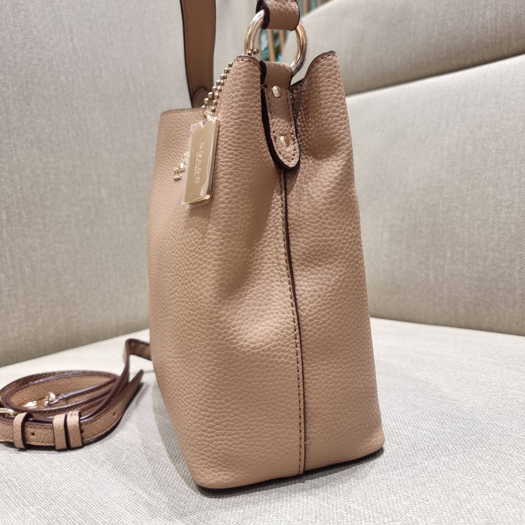 COACH 1011 SMALL TOWN BUCKET BAG รุ่นยอดนิยมใบเล็ก กระเป๋าทรงบัคเก็ต สีคลาสสิคเรียบหรู ตัดกับโลโก้สีทองดูโดดเด่น วัสดุหนัง pepble สวยคมทุกมุมจริงๆ!! เปิด-ปิดด้วยกระดุมแม่เหล็กทั้ง 2 ฝั่ง ภายในเป็นช่องโล่ง มาพร้อมสายสะพายปรับได้ตามตัว ขนาดใบนี้กำลังสวย สะพ