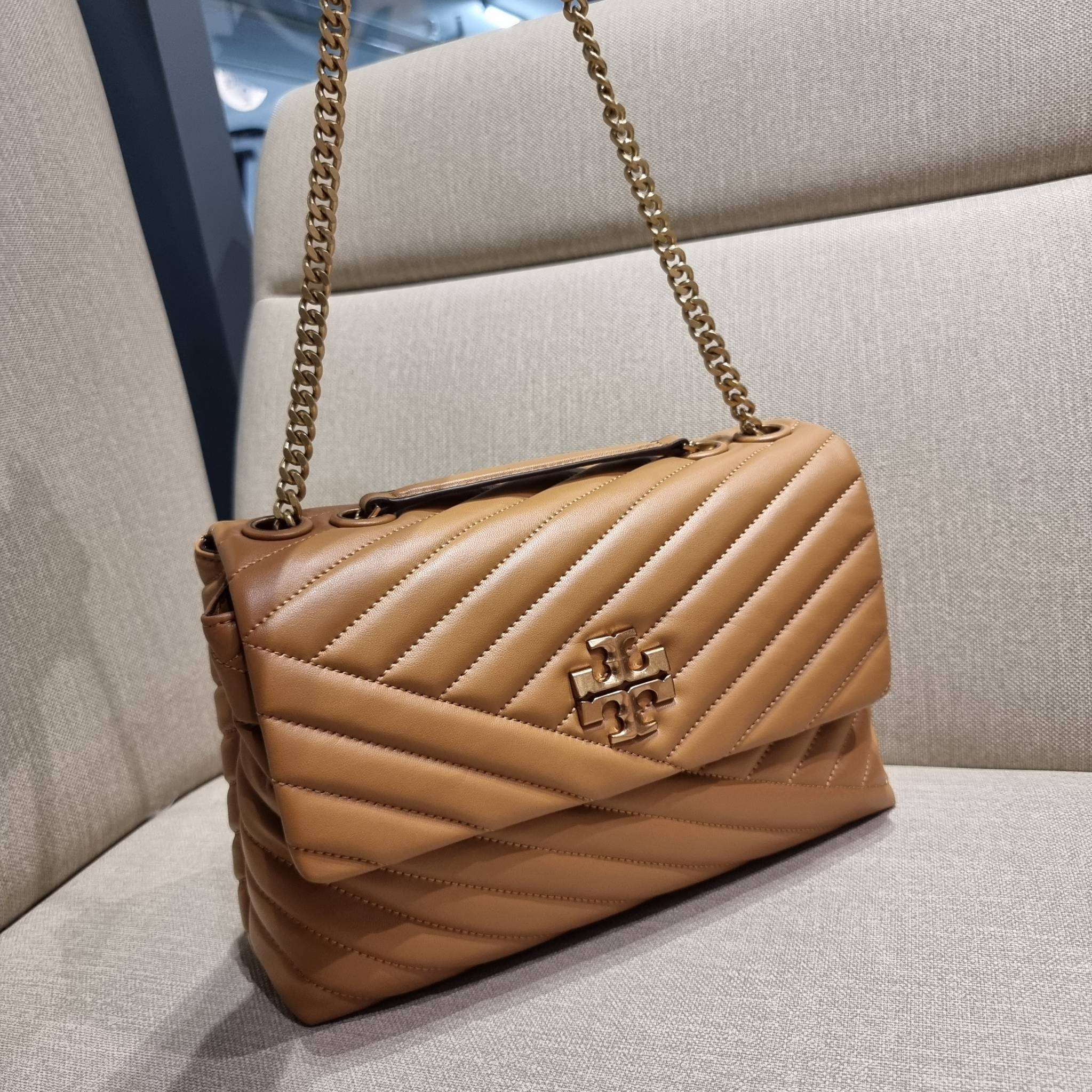 TORY BURCH KIRA CHEVRON CONVERTIBLE SHOULDER BAG กระเป๋าสะพายรุ่นยอดฮิต ไซส์ใหญ่จัดเต็มให้เน้นๆ ใช้ยังไงก็ดูหรู ดีไซน์เฉพาะตัว วัสดุหนังแกะ สัมผัสนิ่ม เปิด-ปิดด้วยกระดุมแม่เหล็ก ภายในเป็นช่องโล่ง แบ่งสัดส่วนไว้ดีมากๆ ใส่กระเป๋าสตางค์ มือถือ เครื่องสำอางค์